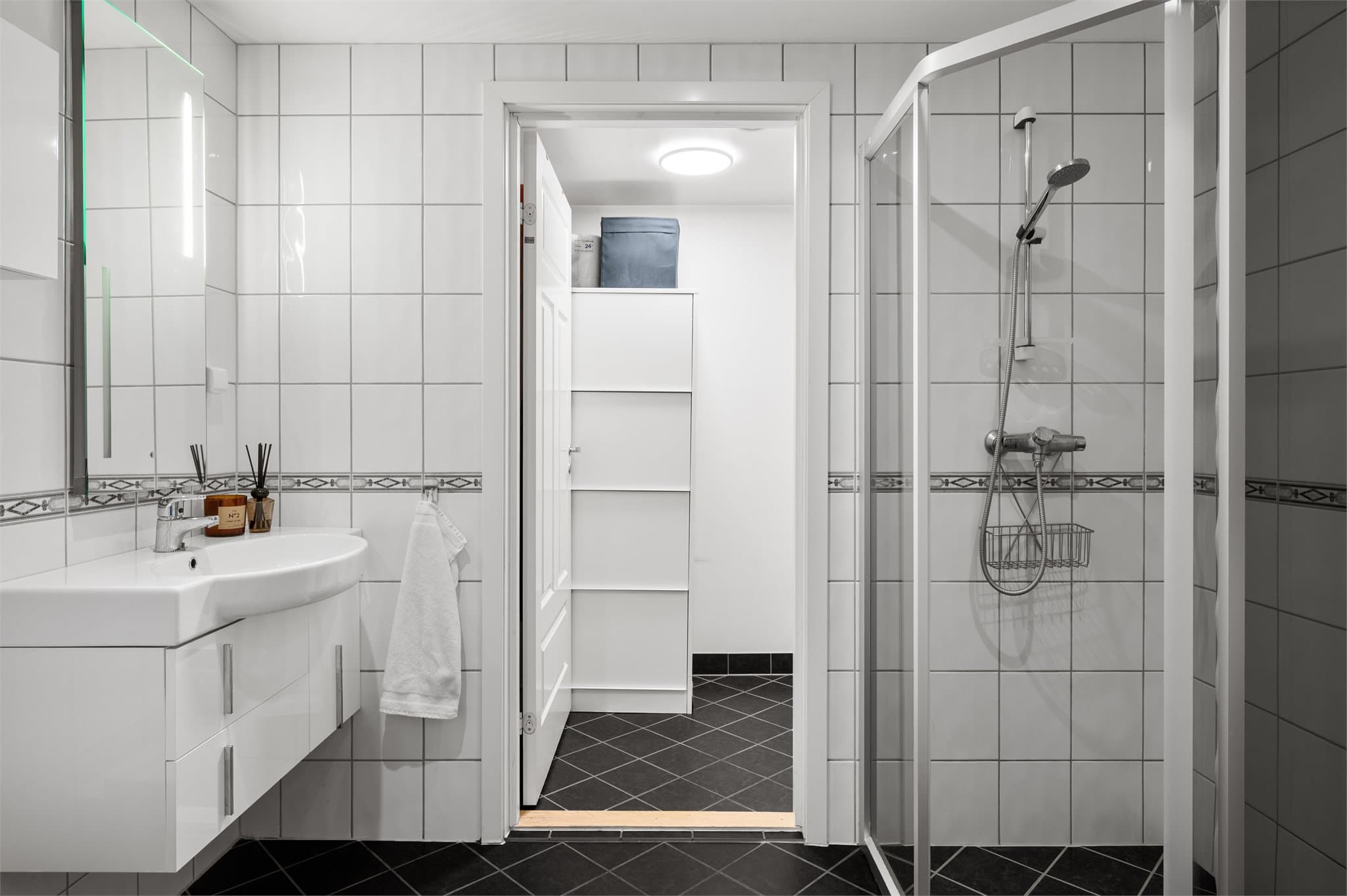 - Badet er innredet med heldekkende servant, speil med belysning, vegghengt toalett, og buet hjørnedusj -