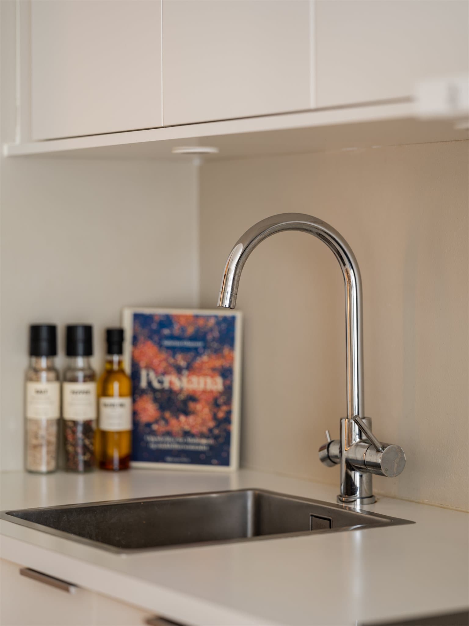 Benkeplaten i hvit laminat har en praktisk, nedfelt vaskekum.