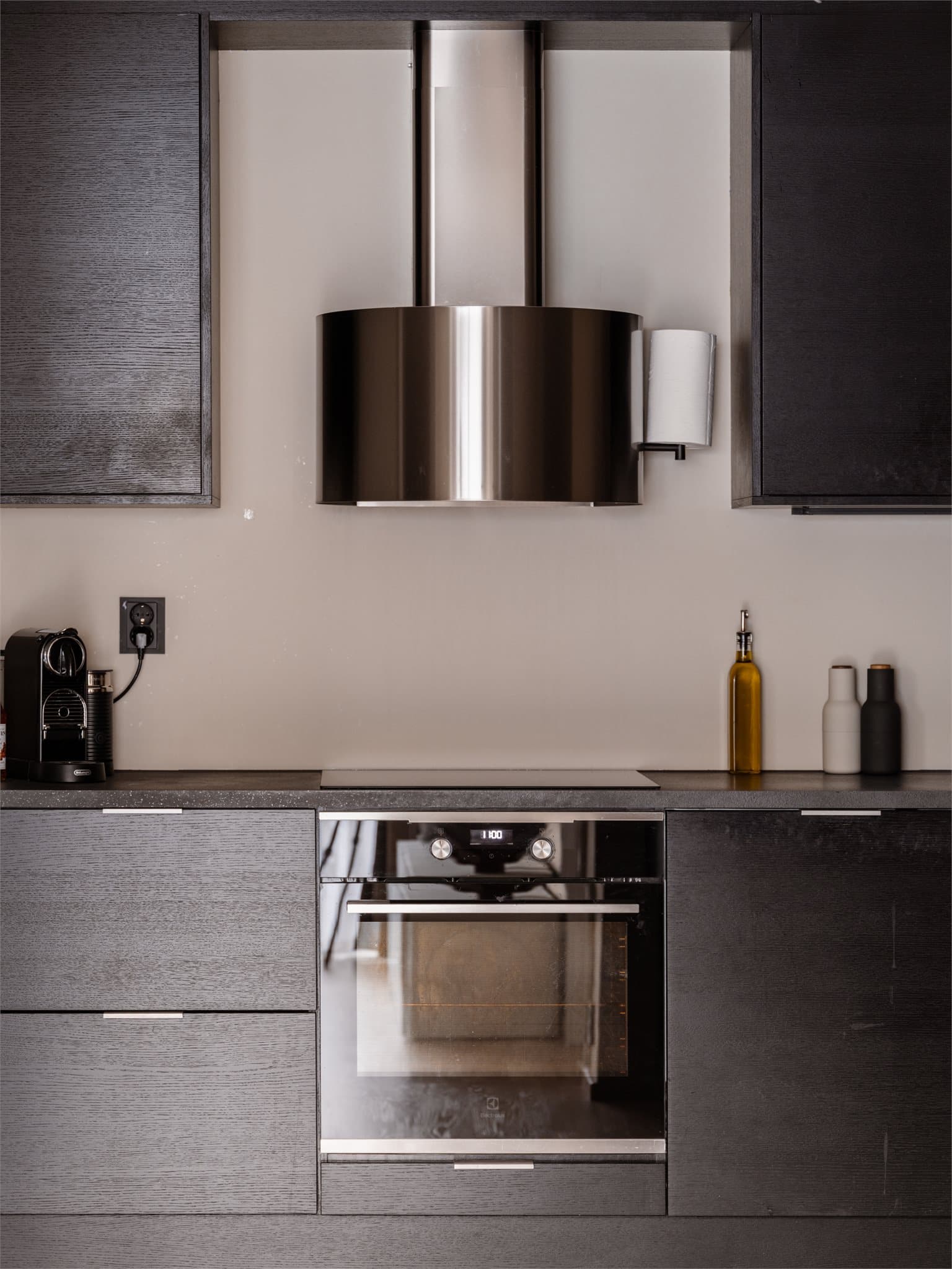 Alle hvitevarer er integrerte, og kjøkkenet har en mørk laminatbenkeplate med nedfelt vaskekum.