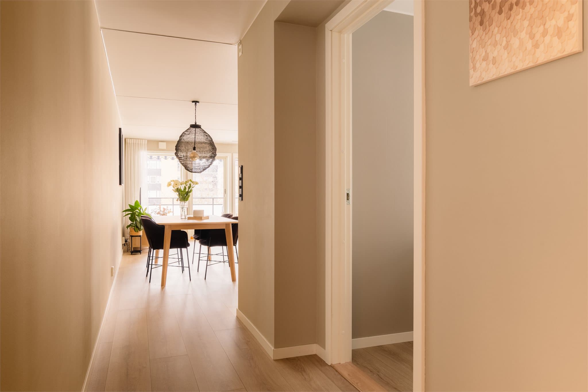 Gjennomgående gulv skaper en helhetlig og sømløs overgang mellom rommene.