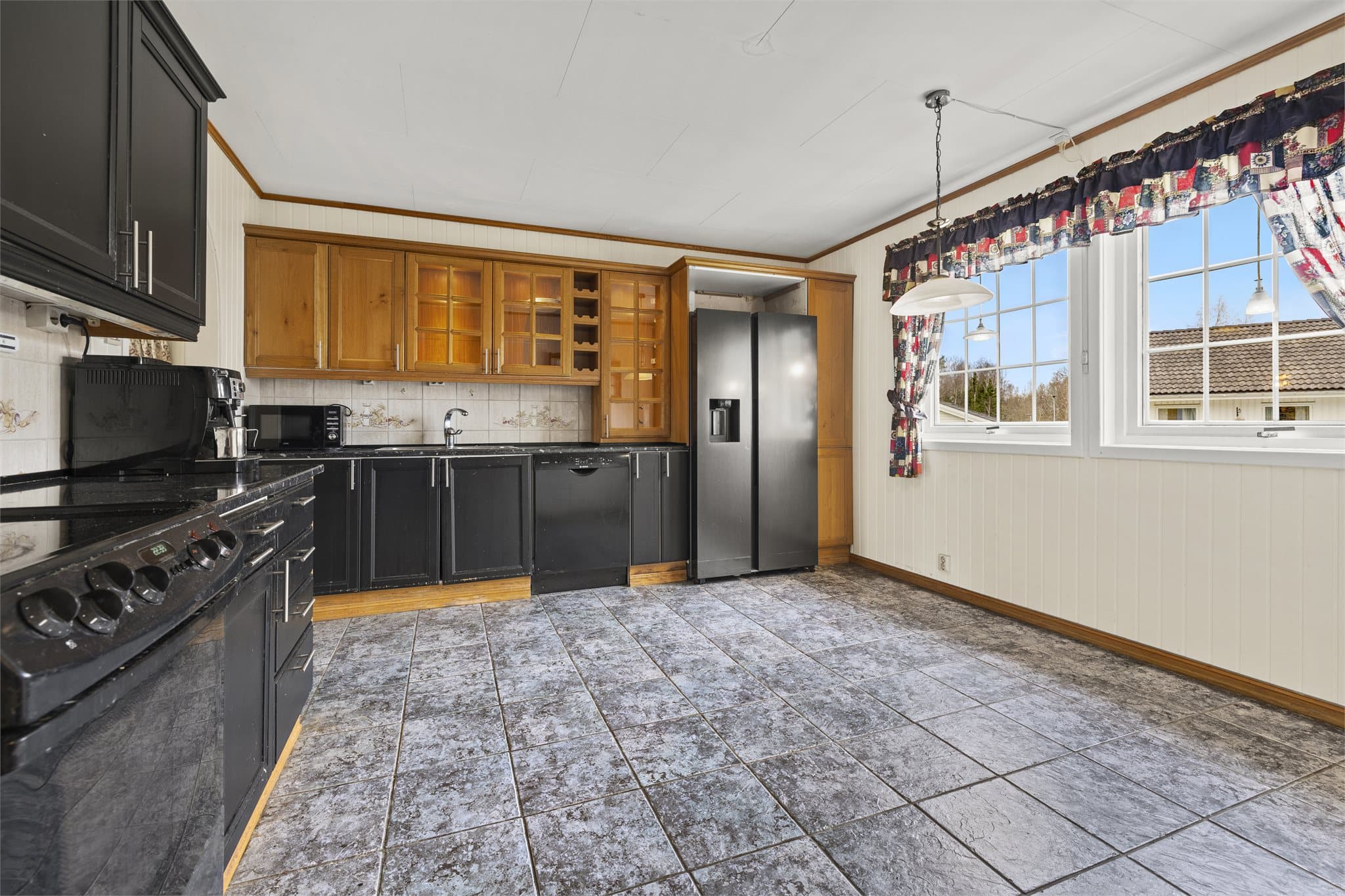 Kjøkkenet har en tradisjonell og praktisk utforming, med profilerte fronter og benkeplate i steinkompositt.