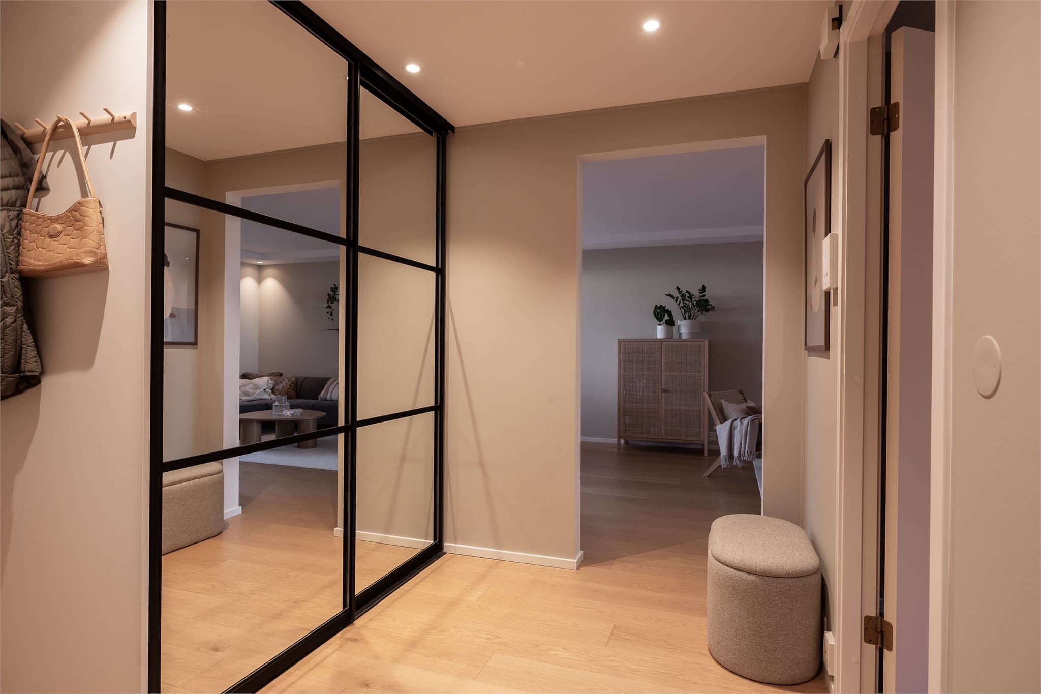 Romslig entré med gode oppbevaringsmuligheter for yttertøy og sko i skyvedørsgarderobe