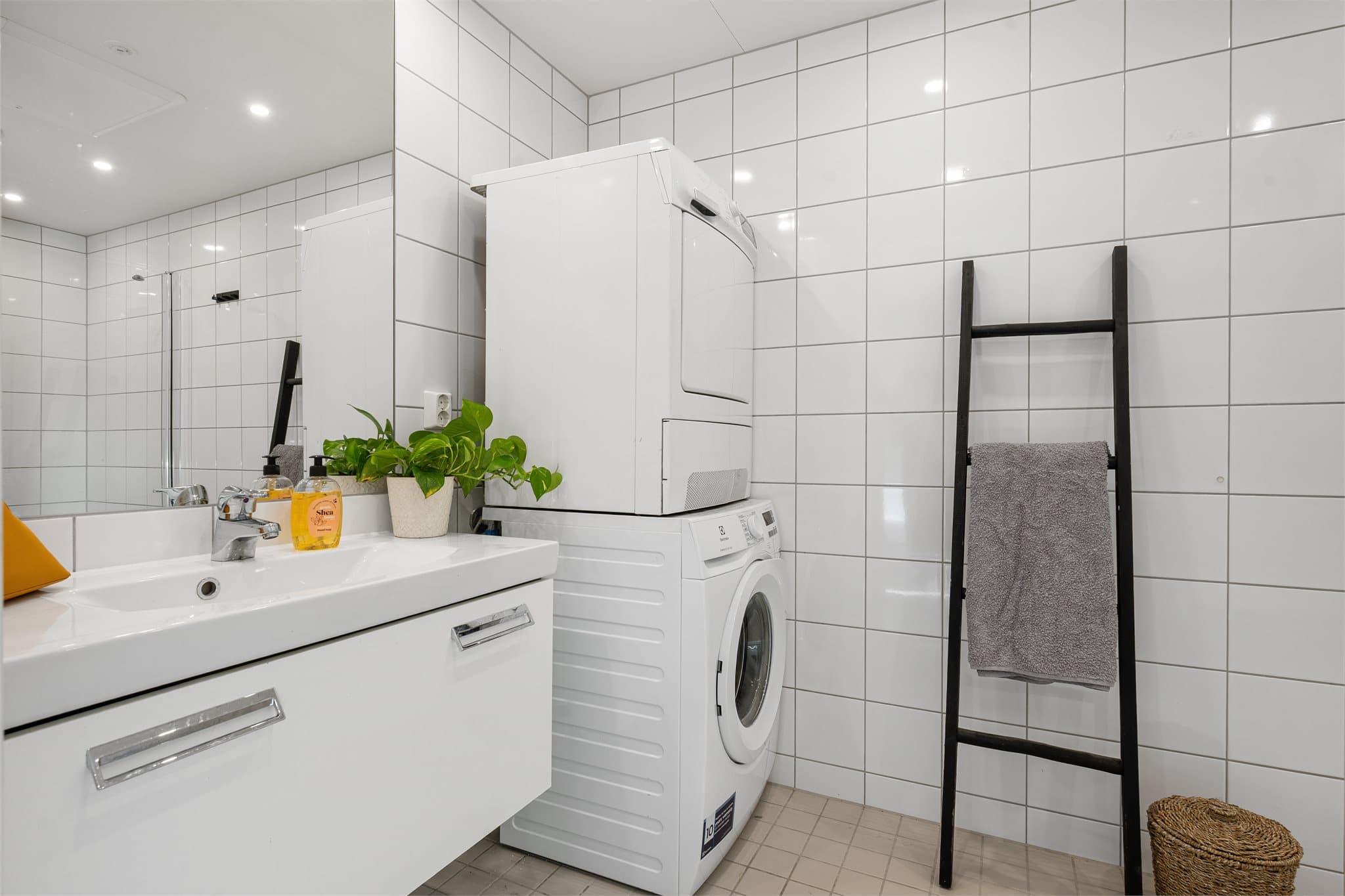 Badet fremstår som klassisk og tidløst, med flislagte overflater som gir et stilrent og lettstelt uttrykk. Rommet er godt utnyttet med en praktisk planløsning, servantinnredning med oppbevaring og speil som gir gode bruksegenskaper i hverdagen.