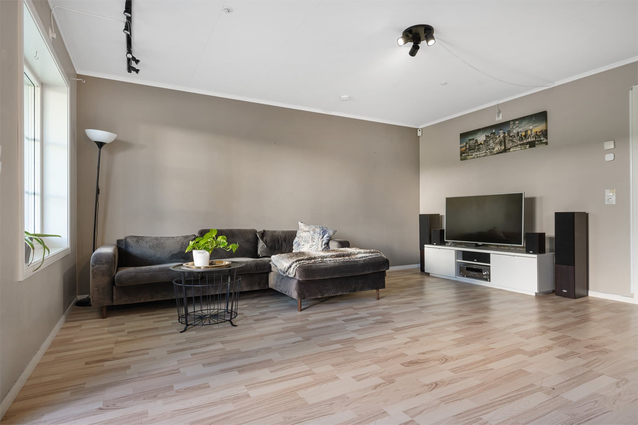 Den åpne løsningen mellom spisestue og stue gir en luftig og sosial romfølelse, med god plass til både spisebord og en komfortabel sofagruppe.