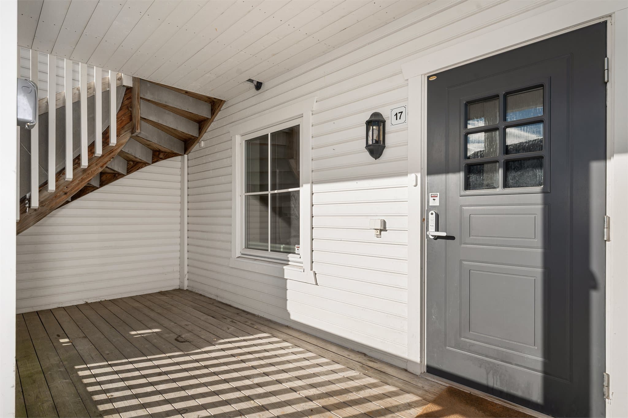 Trivelig inngangsparti på bakkeplan med overbygget velkomstterrasse som gir et lunt og beskyttet førsteinntrykk.