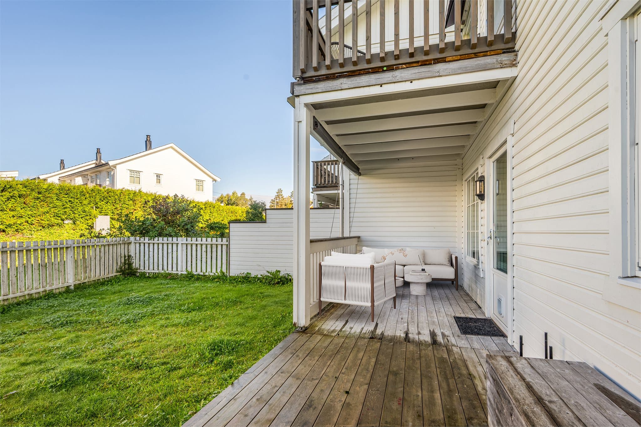 Innbydende markterrasse med delvis takoverbygg fra balkongen over, som gir en lun og skjermet uteplass uansett vær. Her er det god plass til både loungesett og grill – perfekt for avslapning og sosiale sammenkomster. (Digitalt møblert bilde)