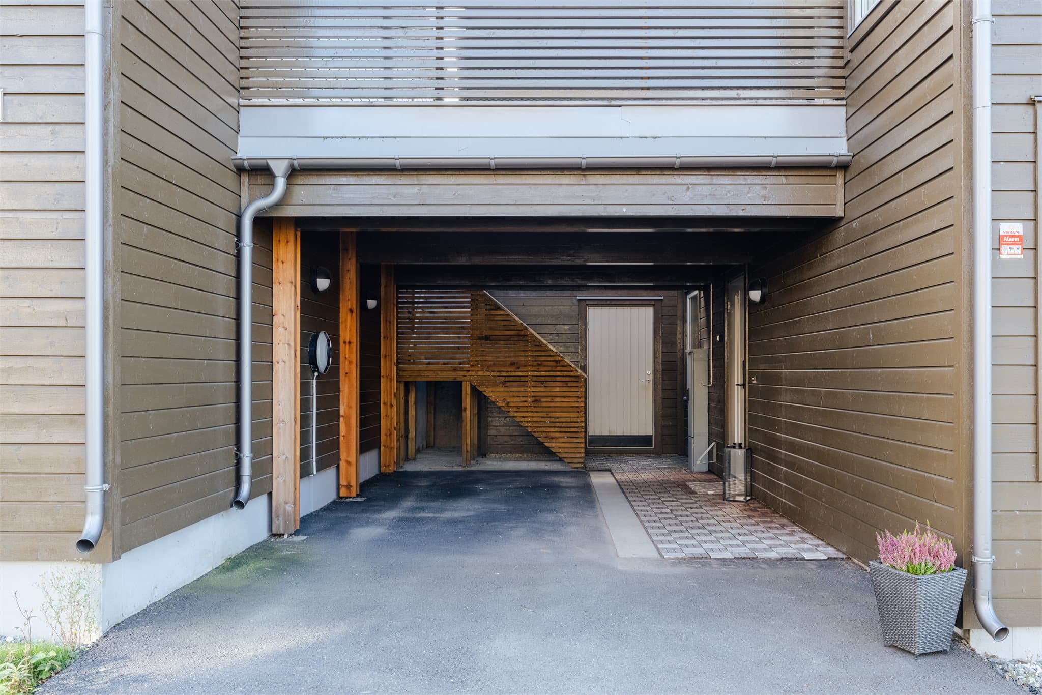Integrert carport ved inngangspartiet og trapp opp til balkongen.