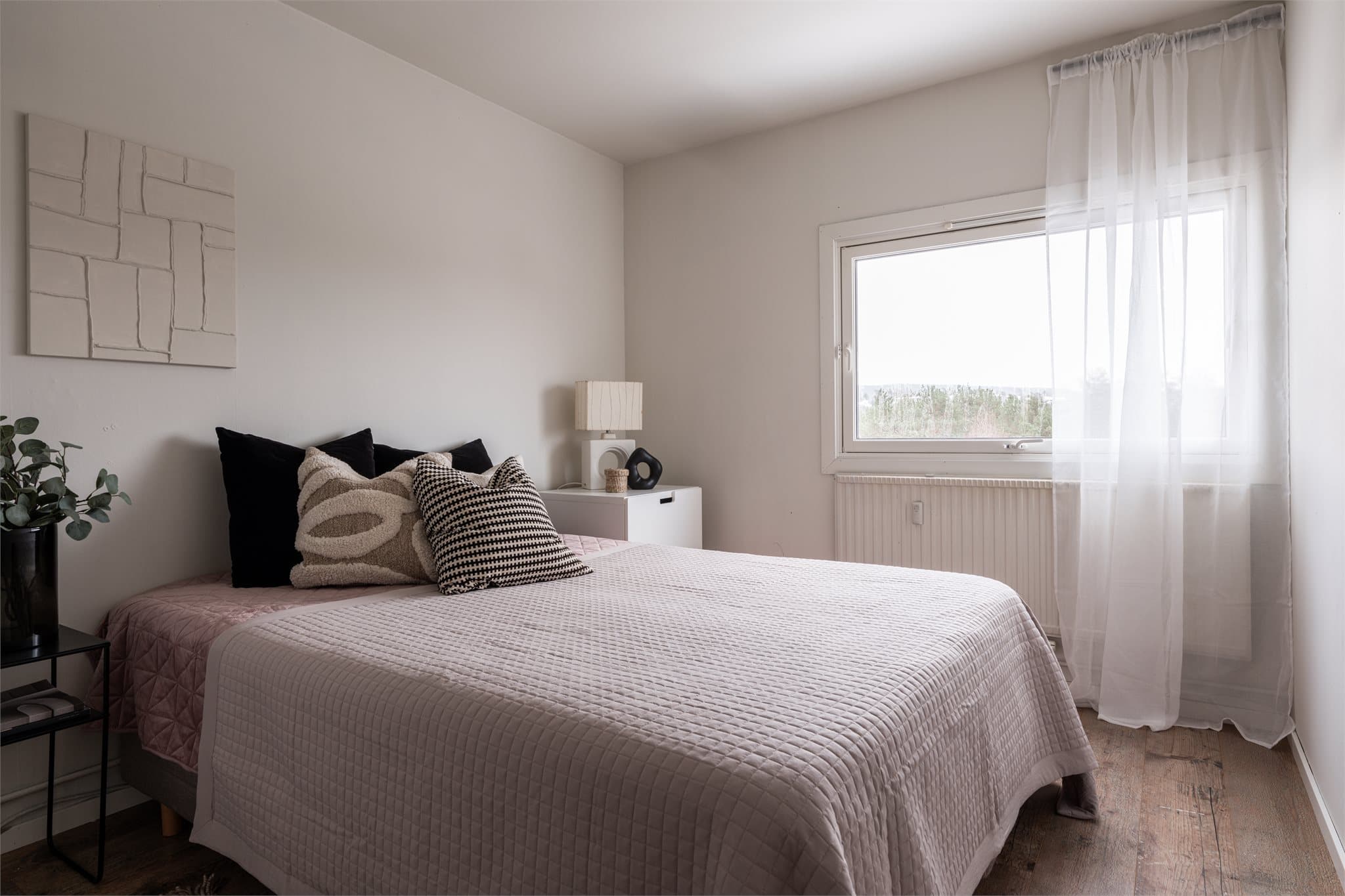 Romslig soverom med god plass til dobbeltseng og nattbord, vendt mot et stille område. Overflatene er malt i 2025.