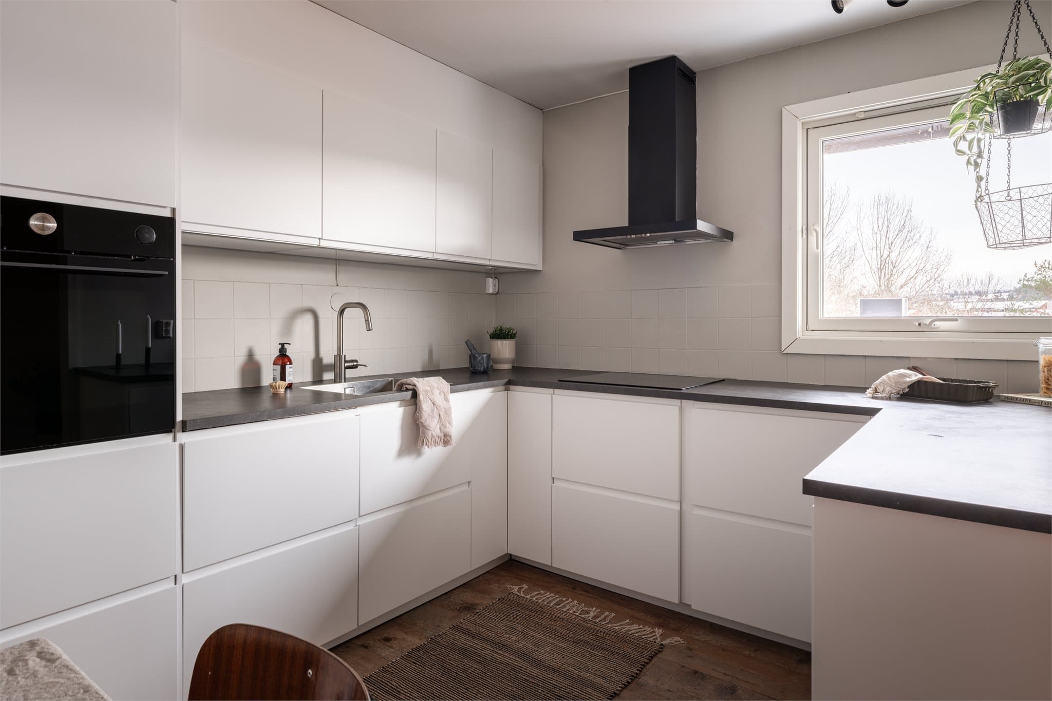 Kjøkkenet har en praktisk U-form som gir rikelig med benke- og skapplass.