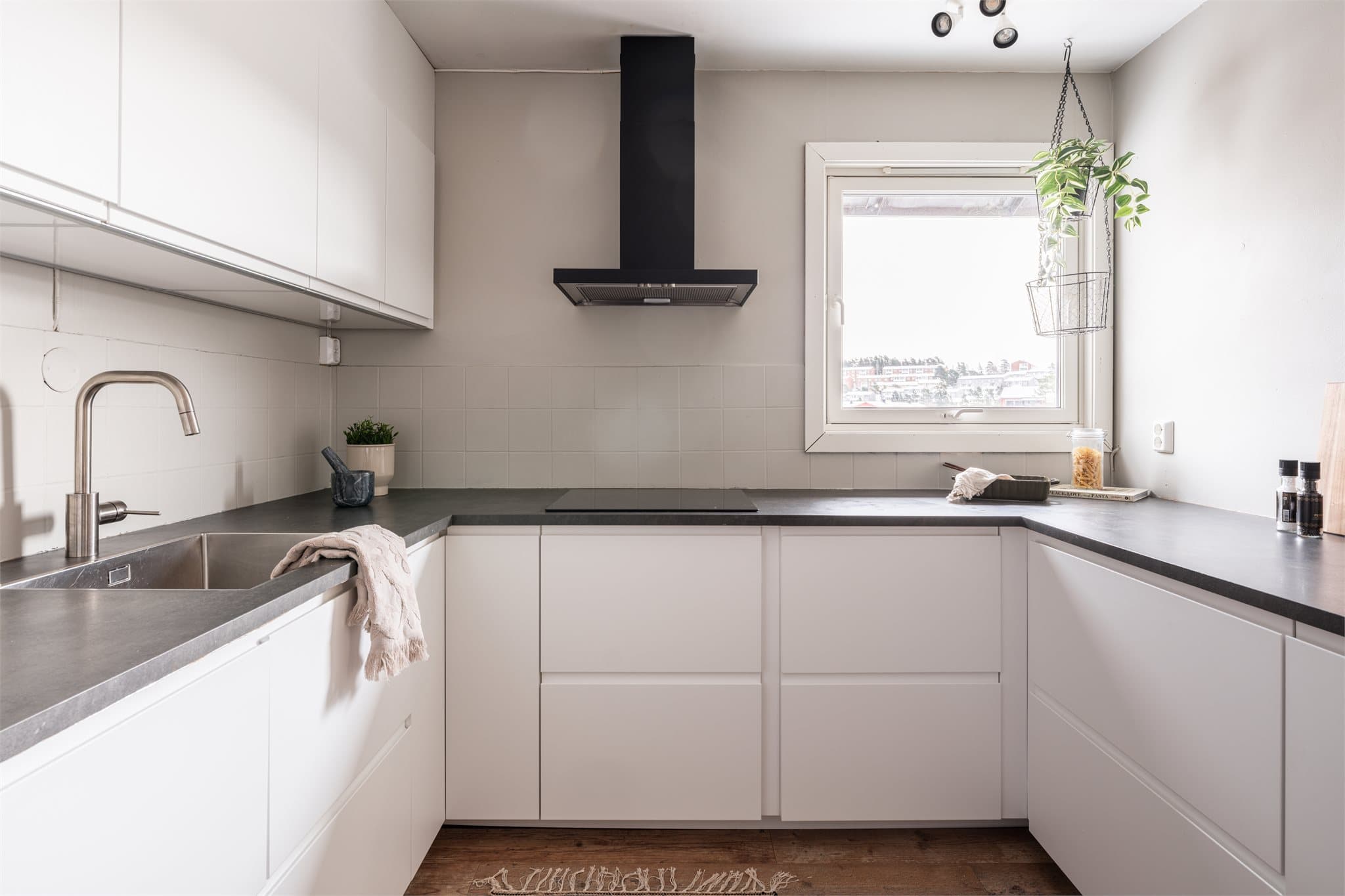 Innredningen har glatte, hvite fronter og en mørk laminatbenkeplate.