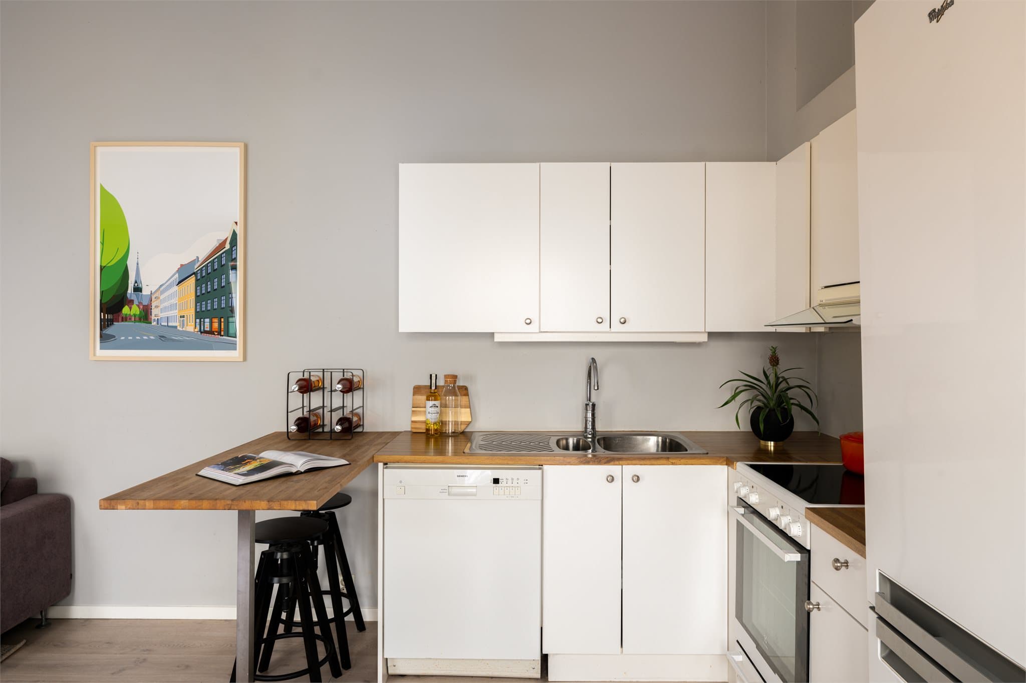 Innredningen har hvite, glatte fronter og laminat benkeplate, med gode arbeidsflater og praktisk oppbevaring.