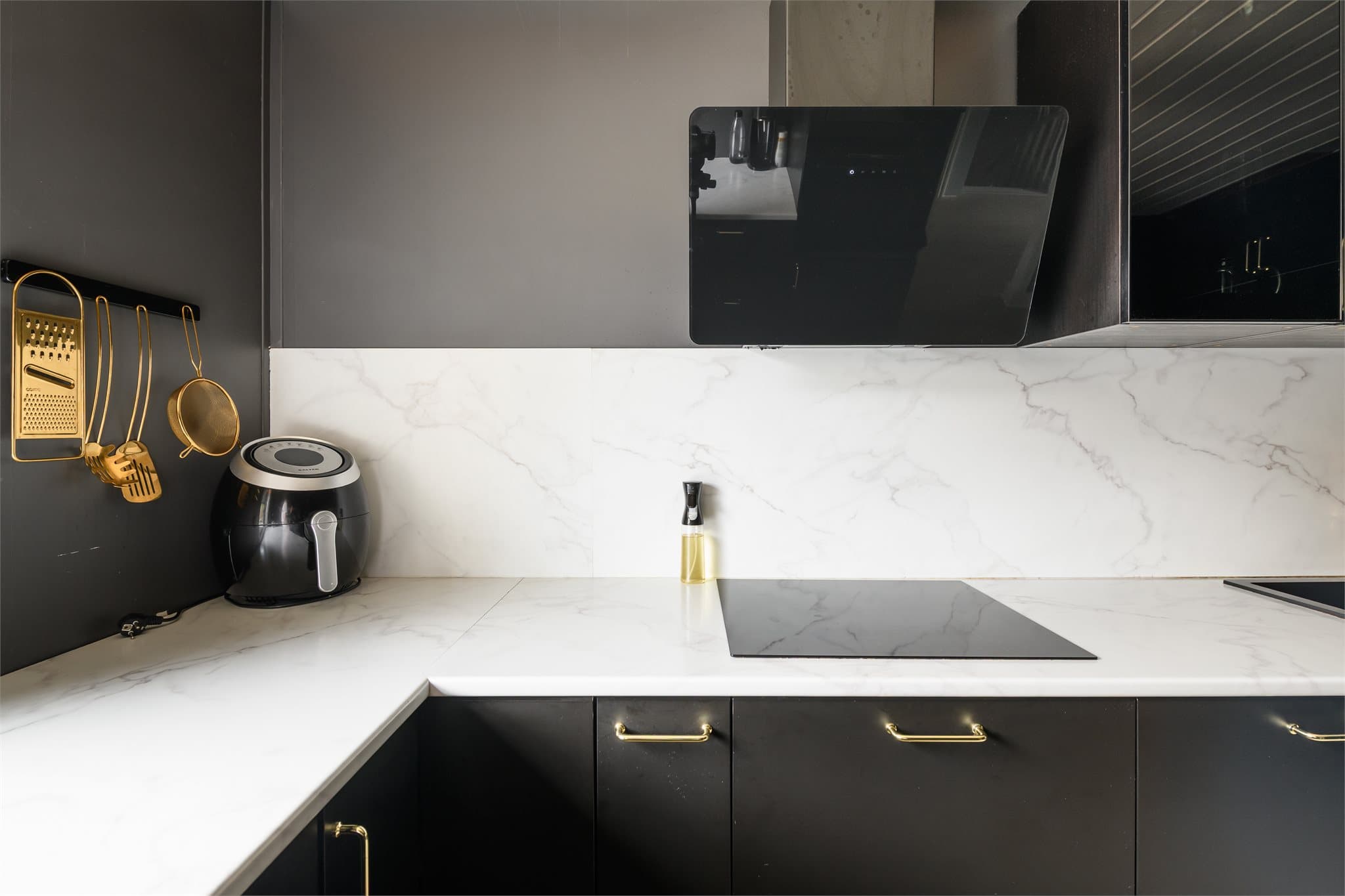 Veggene over benken er kledd med plater som matcher laminatbenkeplaten i marmor-look.