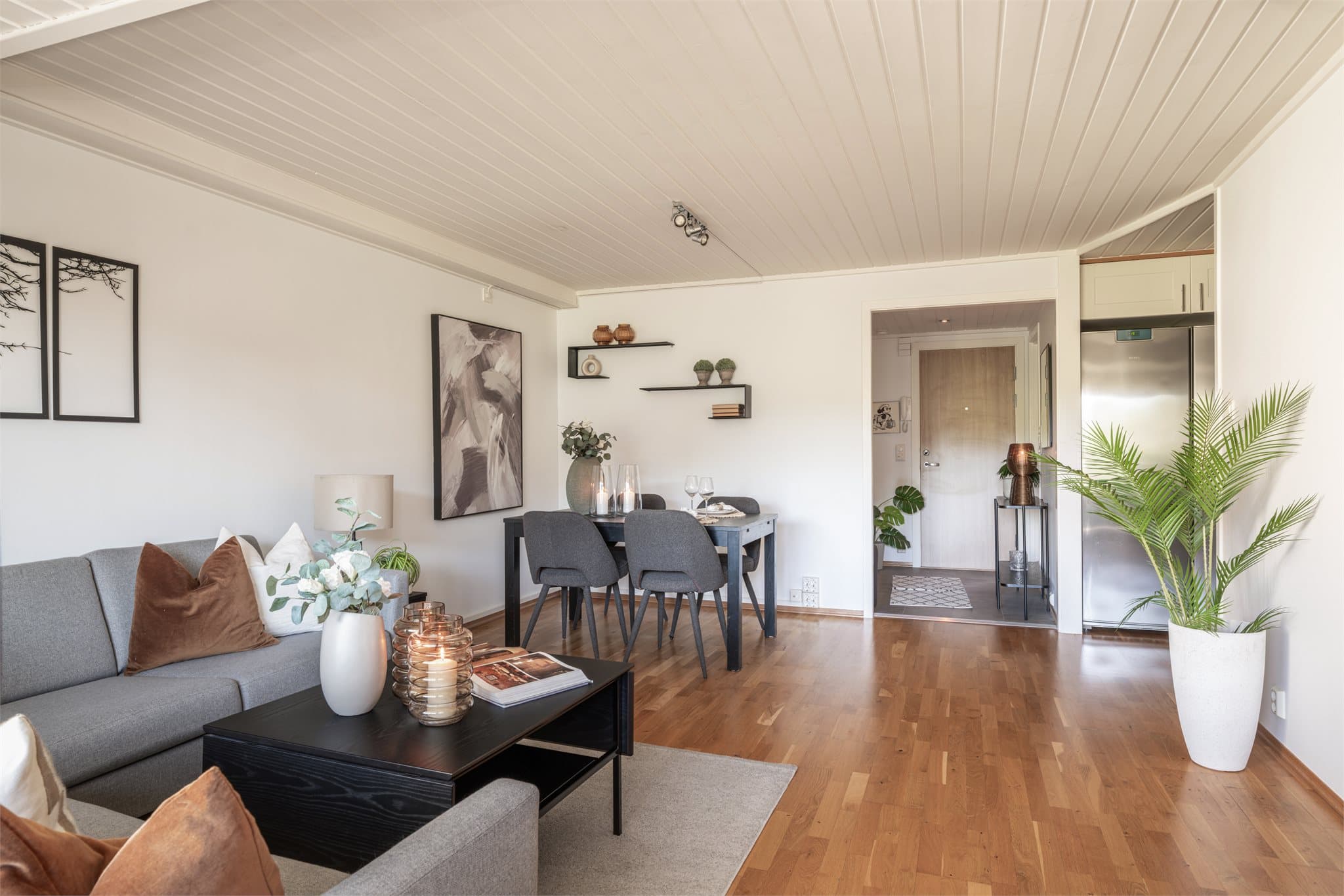 Leiligheten har hvitmalt paneltak med innfelte downlights og 3-stavs eikeparkett på gulv.