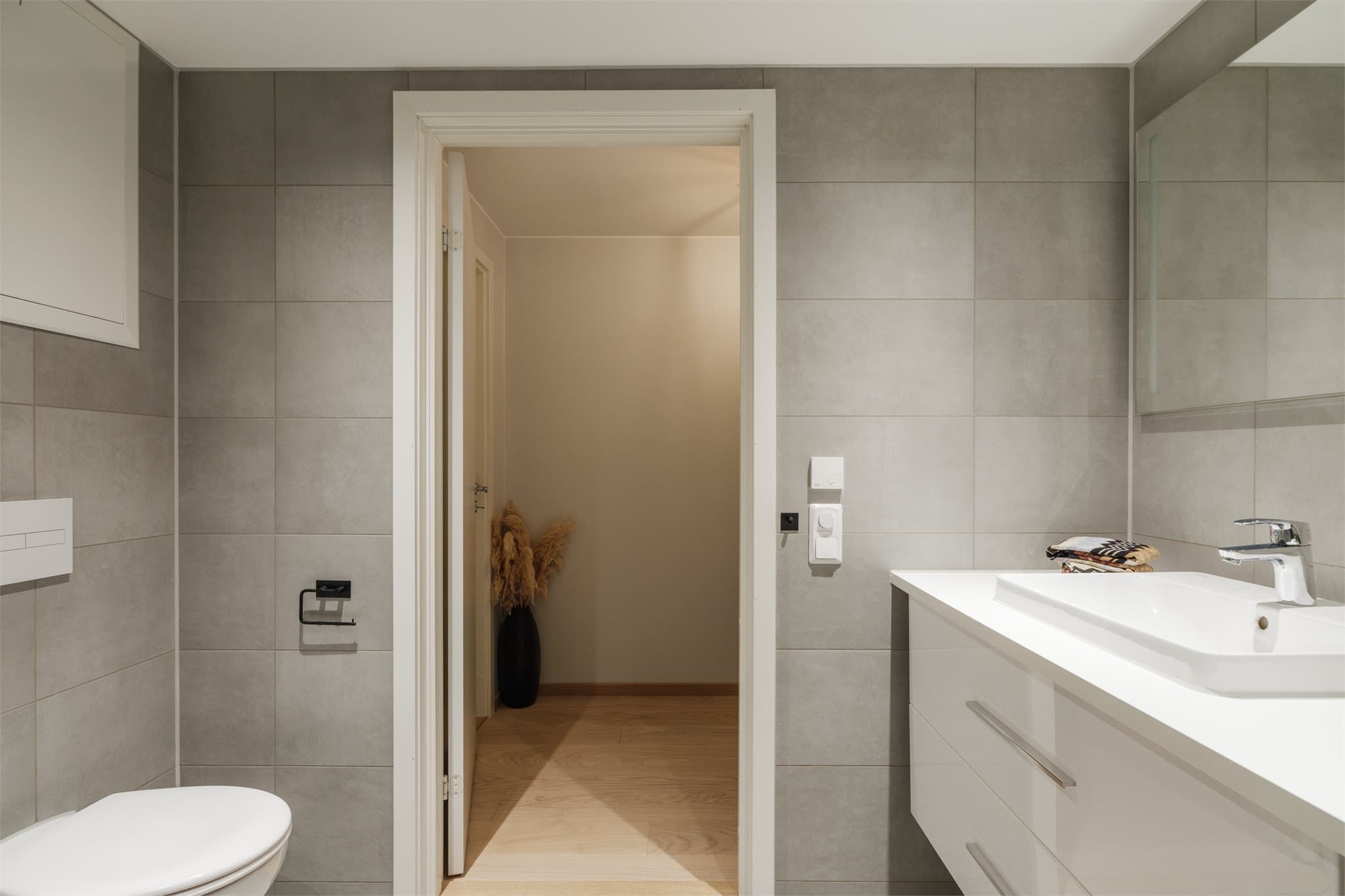 Baderommet oppleves luftig og har elegante flislagte overflater.