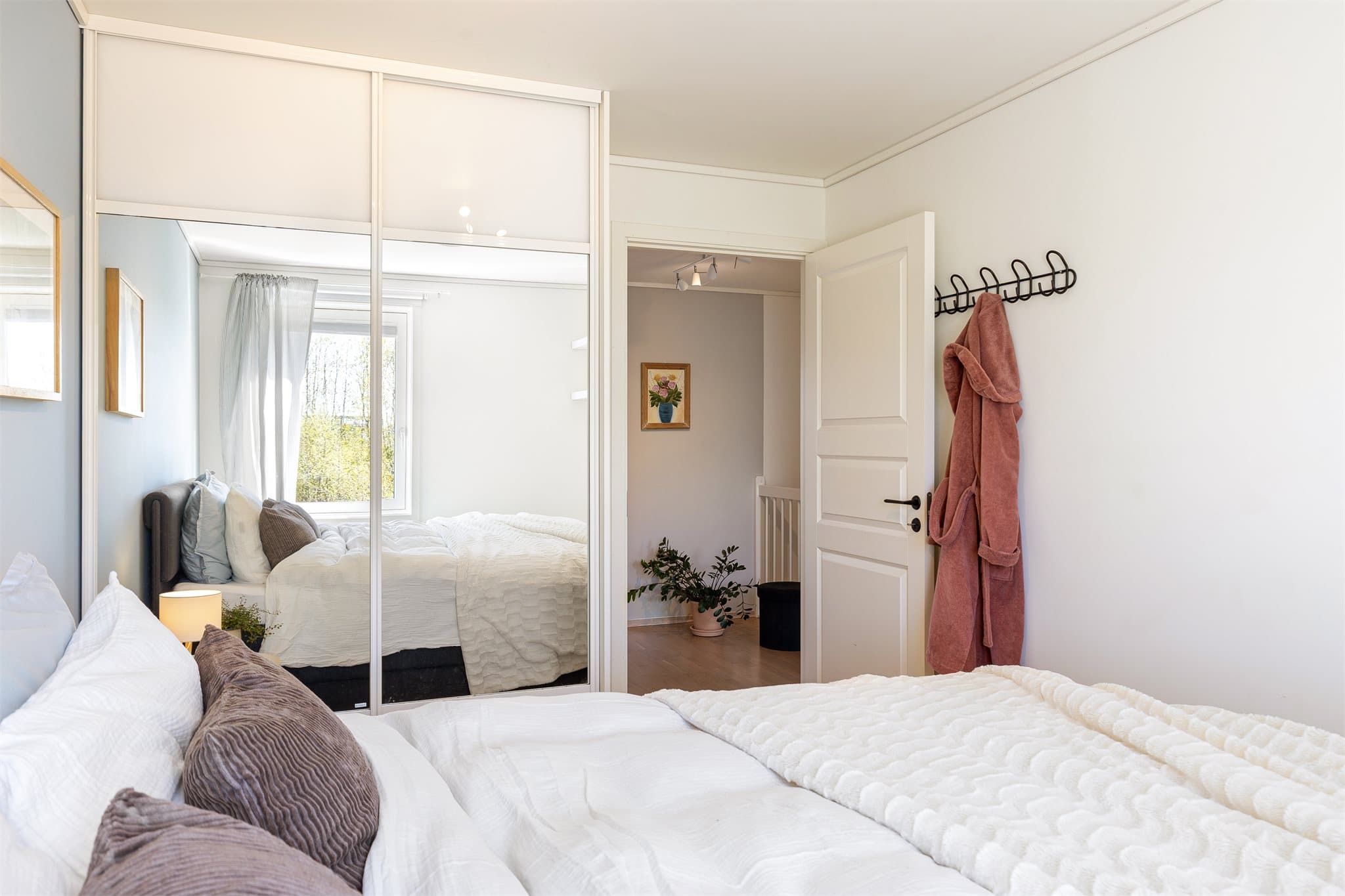Det er montert en romslig skyvedørsgarderobe med speilfronter.