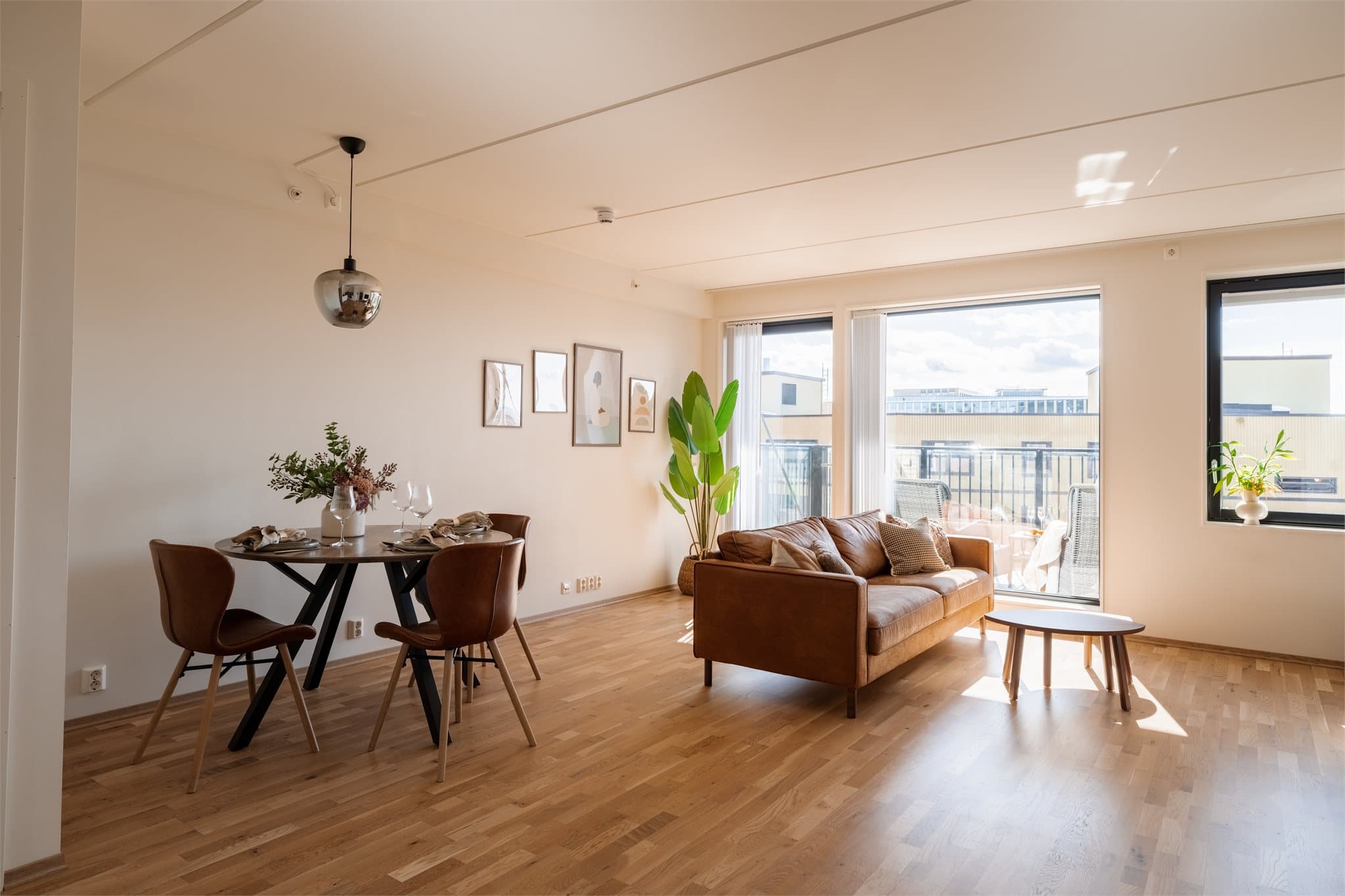 En lys og romslig stue med store vinduer og godt naturlig lysinnslipp.