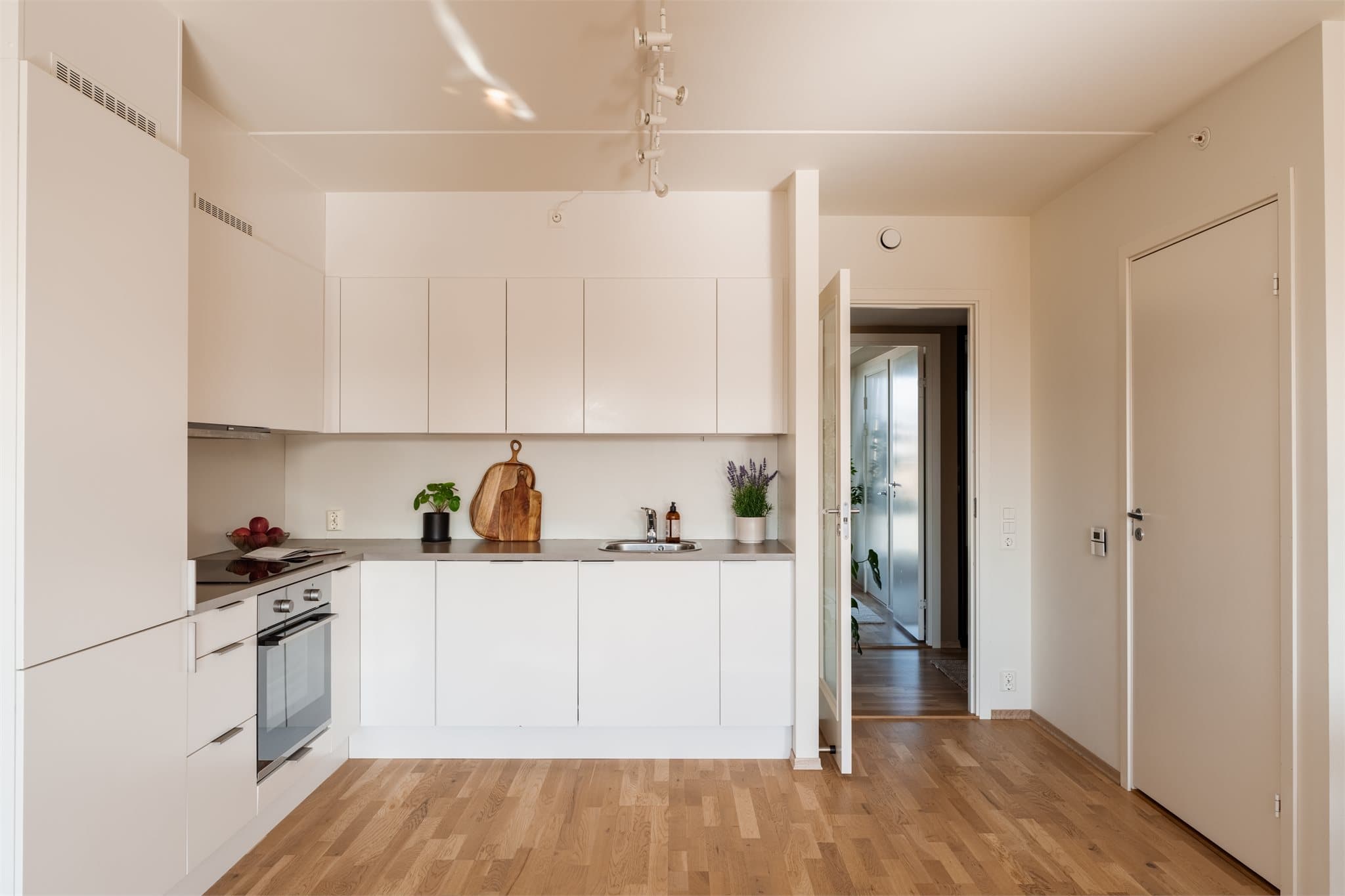 Integrerte hvitevarer som oppvaskmaskin, stekeovn, induksjon koketopp og kjøleskap med frysedel.