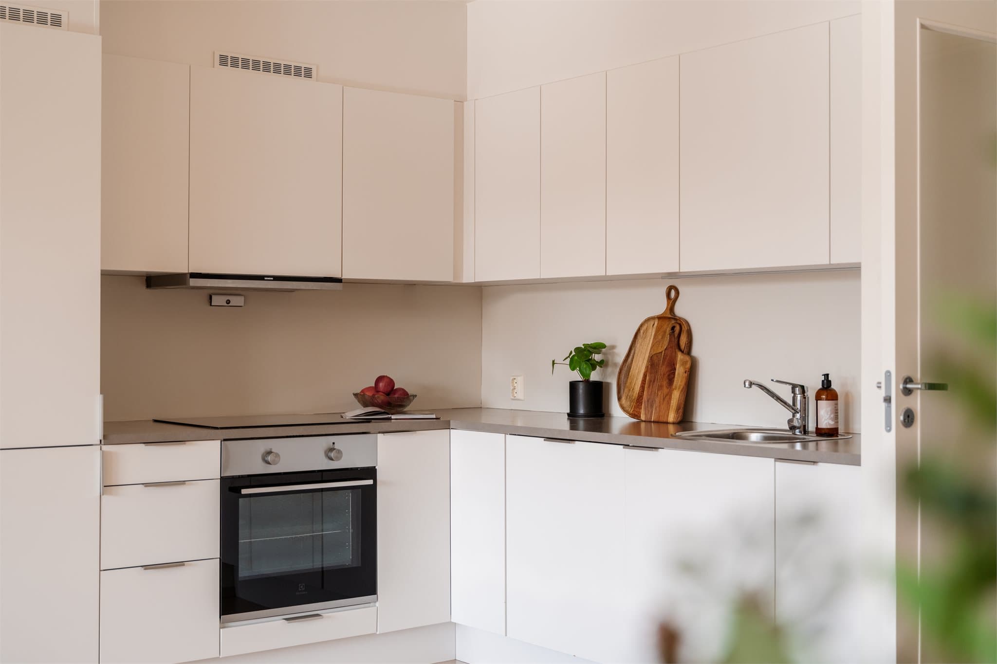 Et lyst og tidløst kjøkken med god kombinasjon av skap- og benkeplass.