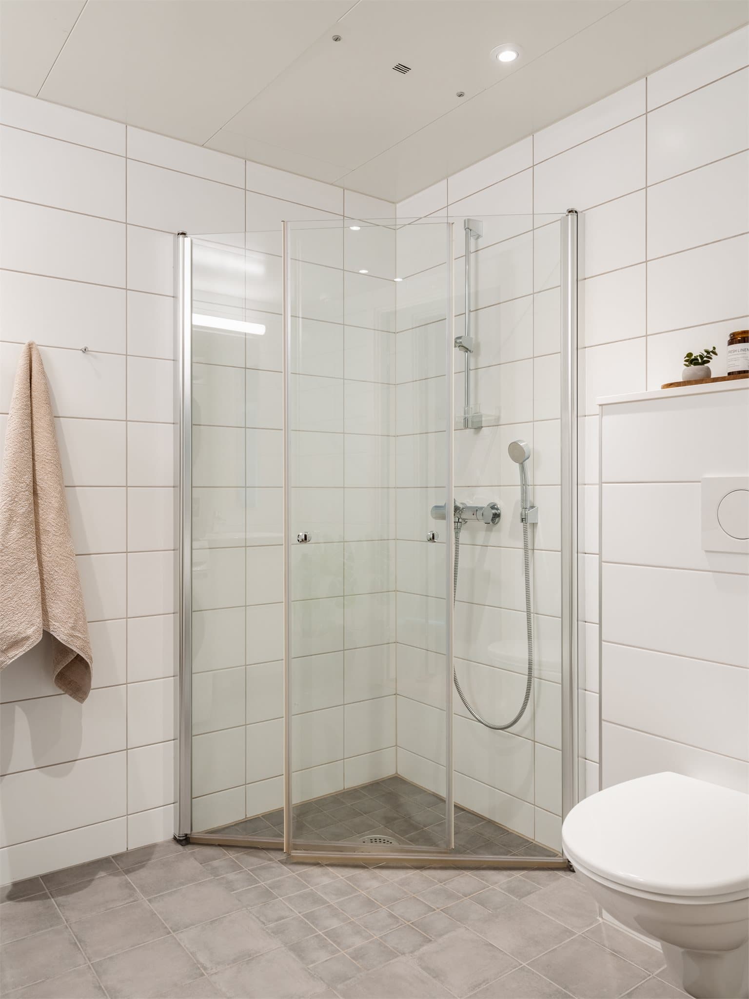 Badet er lyst og innbydende, med downlights i taket og gulvvarme.