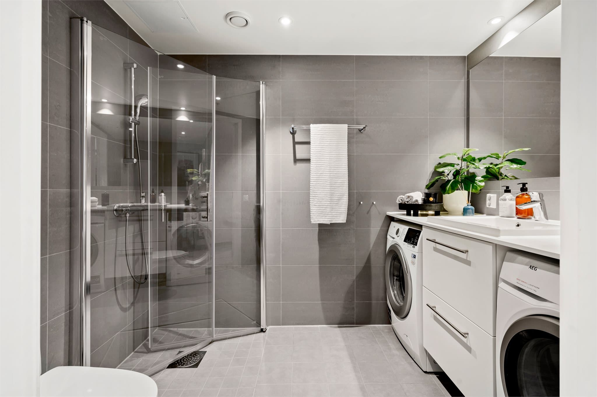 Pent flislagt bad som er moderne innredet med god oppbevaringsplass. Her er det gjort tilvalg på veggflisene som er oppgradert til 30x60 cm Porcelanto, Marte Elegance Grey- et eksklusivt tilvalg som gir rommet et elegant og tidløst uttrykk.