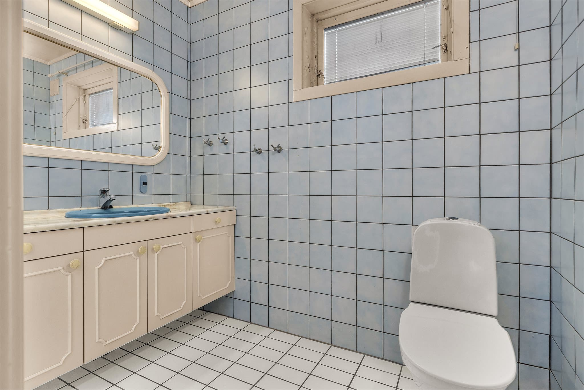 Badet har flislagte overflater med gulvvarme og baderomsinnredning med profilert front.