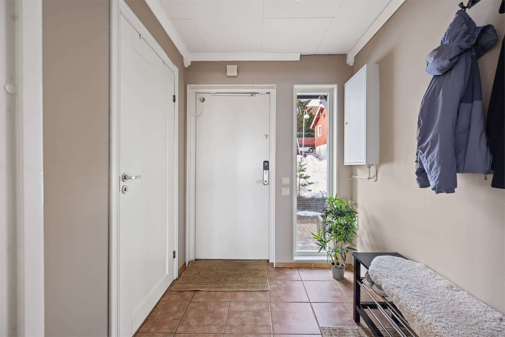 Praktisk entré med flislagt gulv og plass til yttertøy.