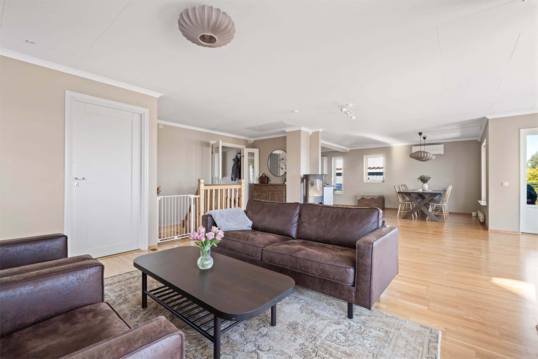 Gjennomgående parkettgulv og lyse overflater skaper en helhetlig atmosfære.