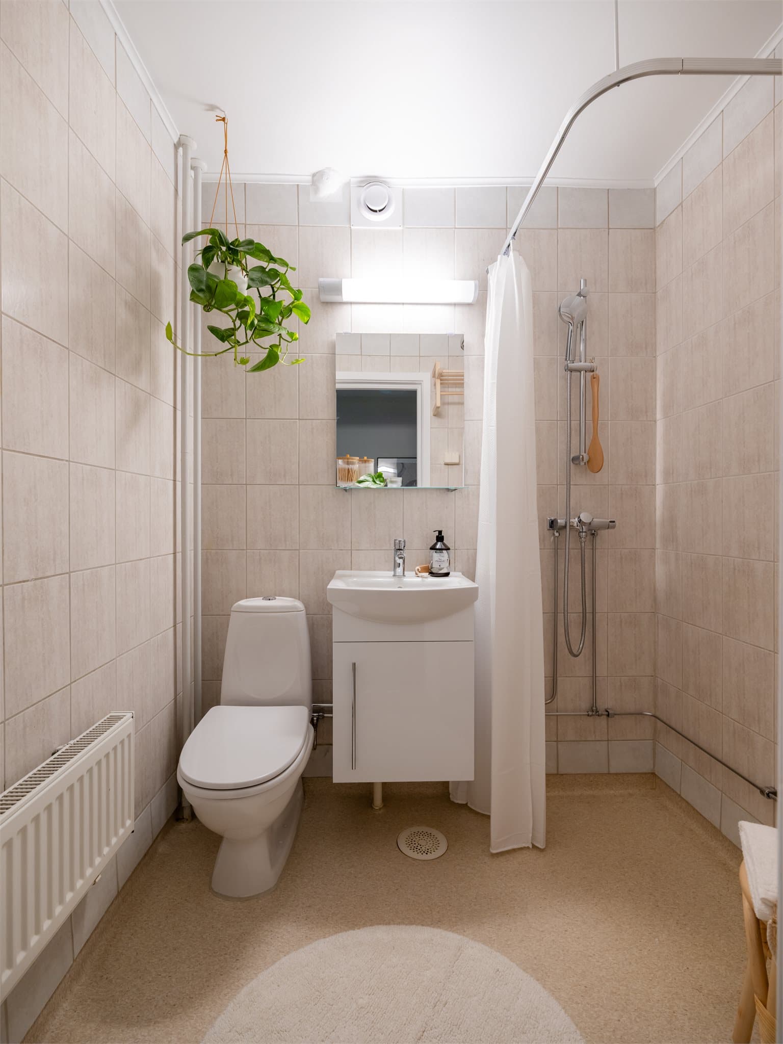 Badet er utstyrt med dusj, toalett, servant med skap og har opplegg for vaskemaskin.