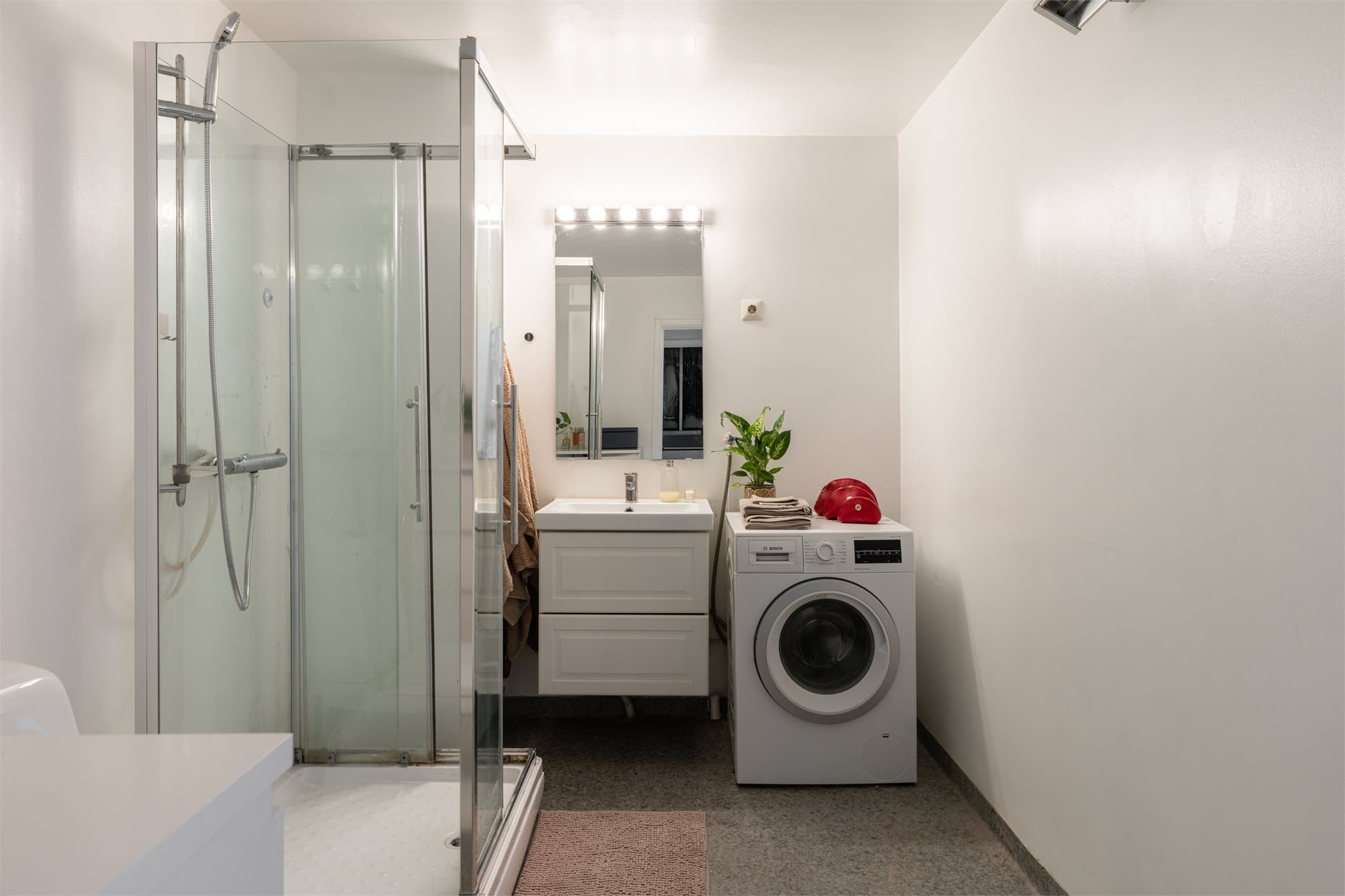 Her er det dusjkabinett, gulvstående toalett og praktisk opplegg for vaskemaskin.