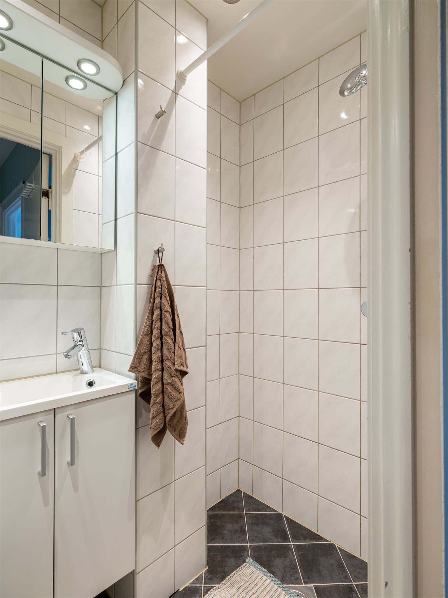 Badet har downlights i himlingen og integrert belysning over speilet.