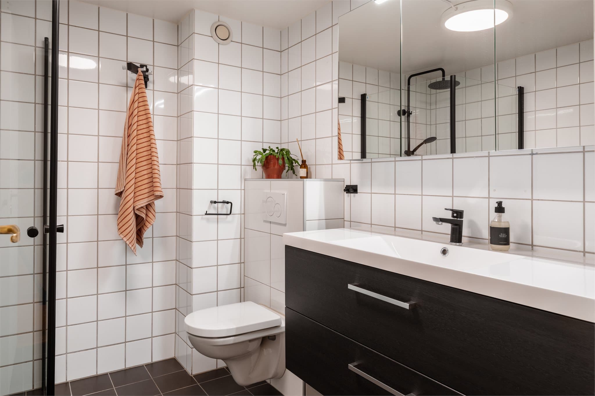 Romslig baderom med flislagte overflater og deilig varme i gulvet.