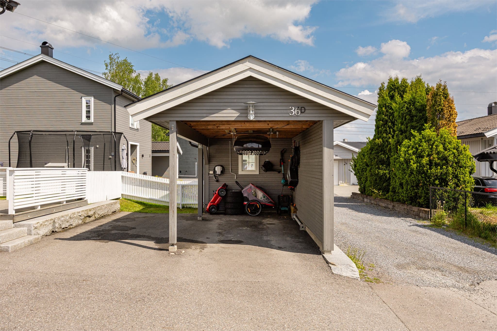 Parkering i carport og på utvendig biloppstillingsplass. Det er montert elbil-lader i carport.