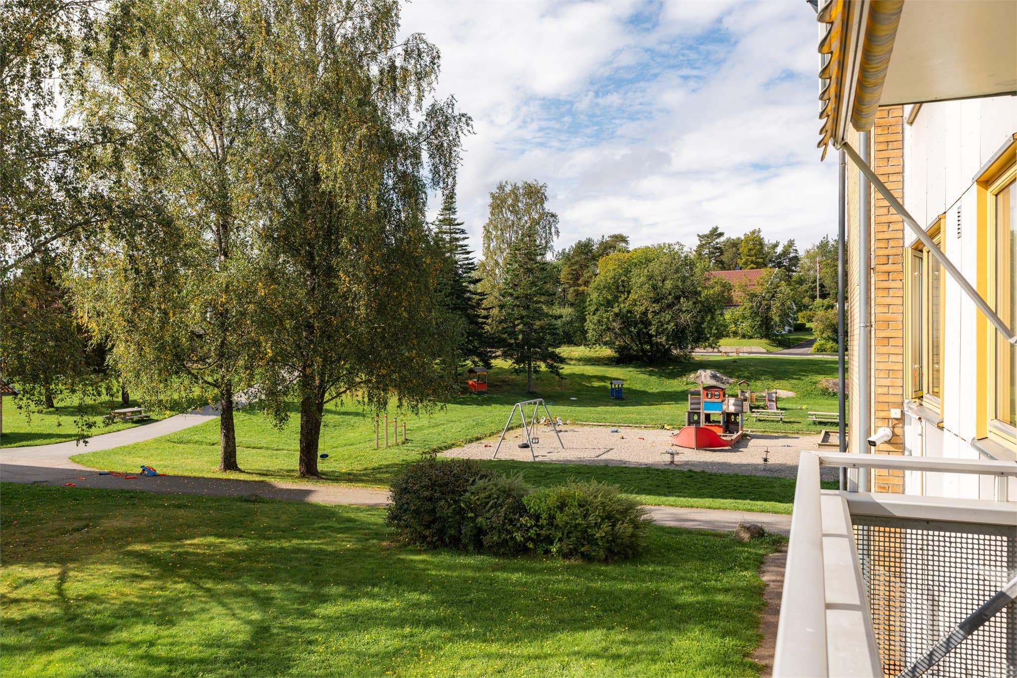 Balkongen har hyggelig utsikt mot grønne omgivelser.