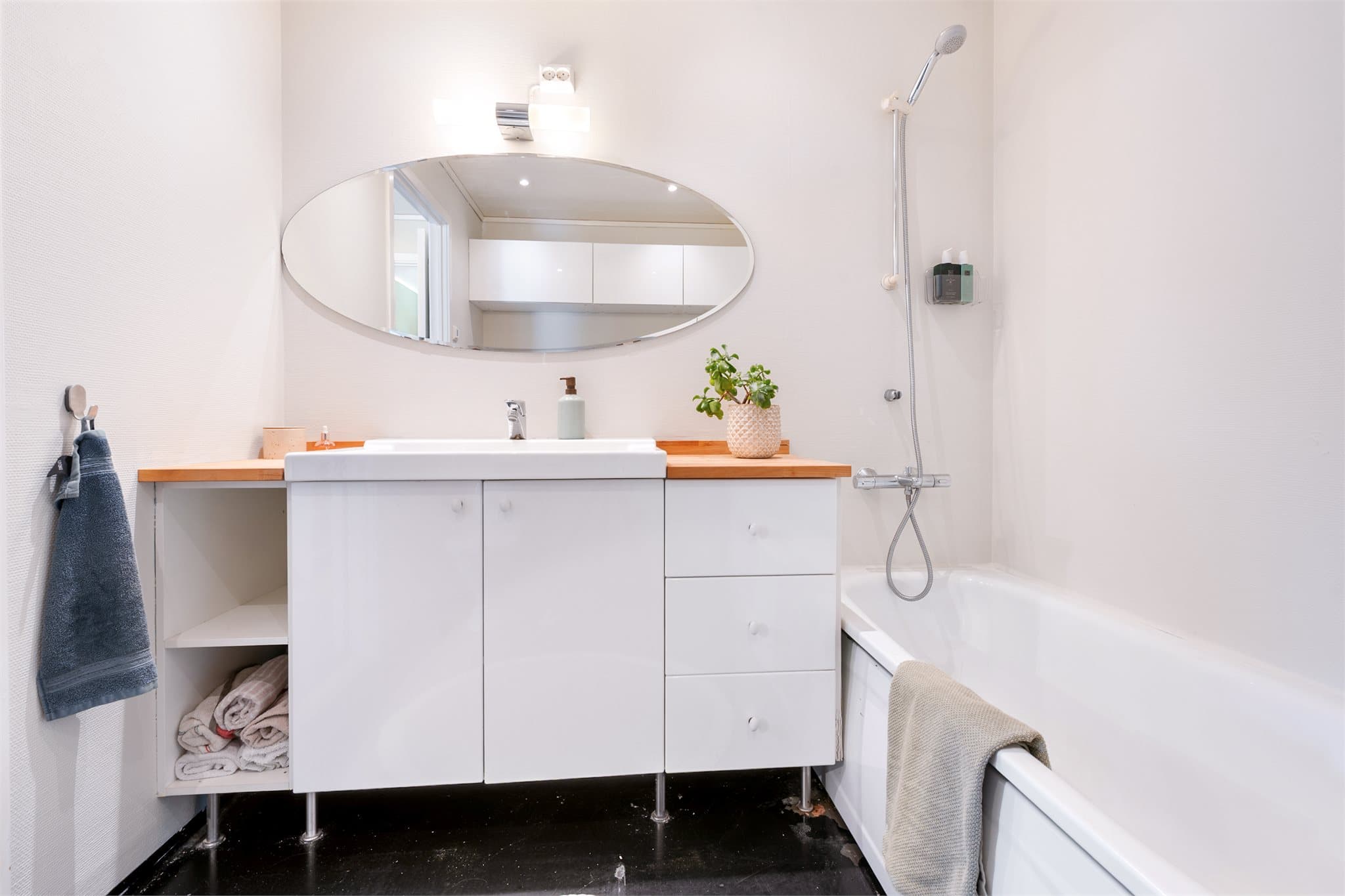 Badet er innredet med helservant på skapseksjon, badekar og klosett. Opplegg for vaskemaskin.
