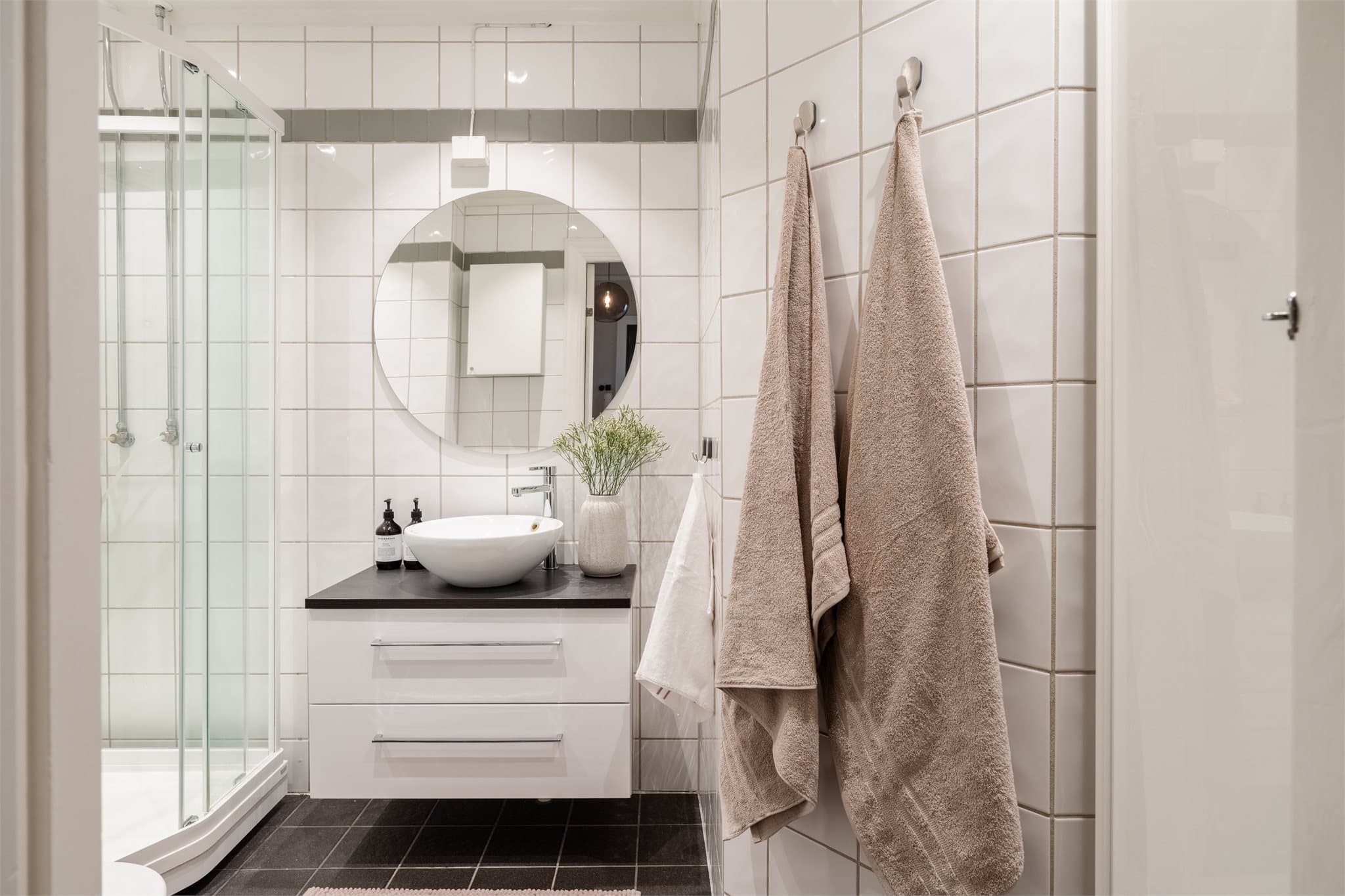 Badet er lyst og funksjonelt, innredet med servant med underskap, toalett og dusjkabinett, samt opplegg for vaskemaskin.