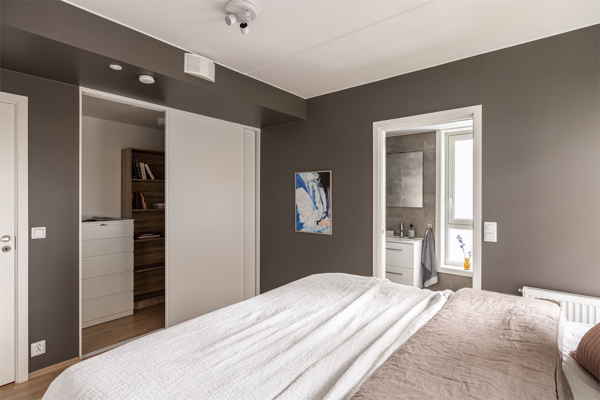 Rommet er tilknyttet eget bad, og god lagringsplass med både skyvedørsgarderobe og omkledningsrom.