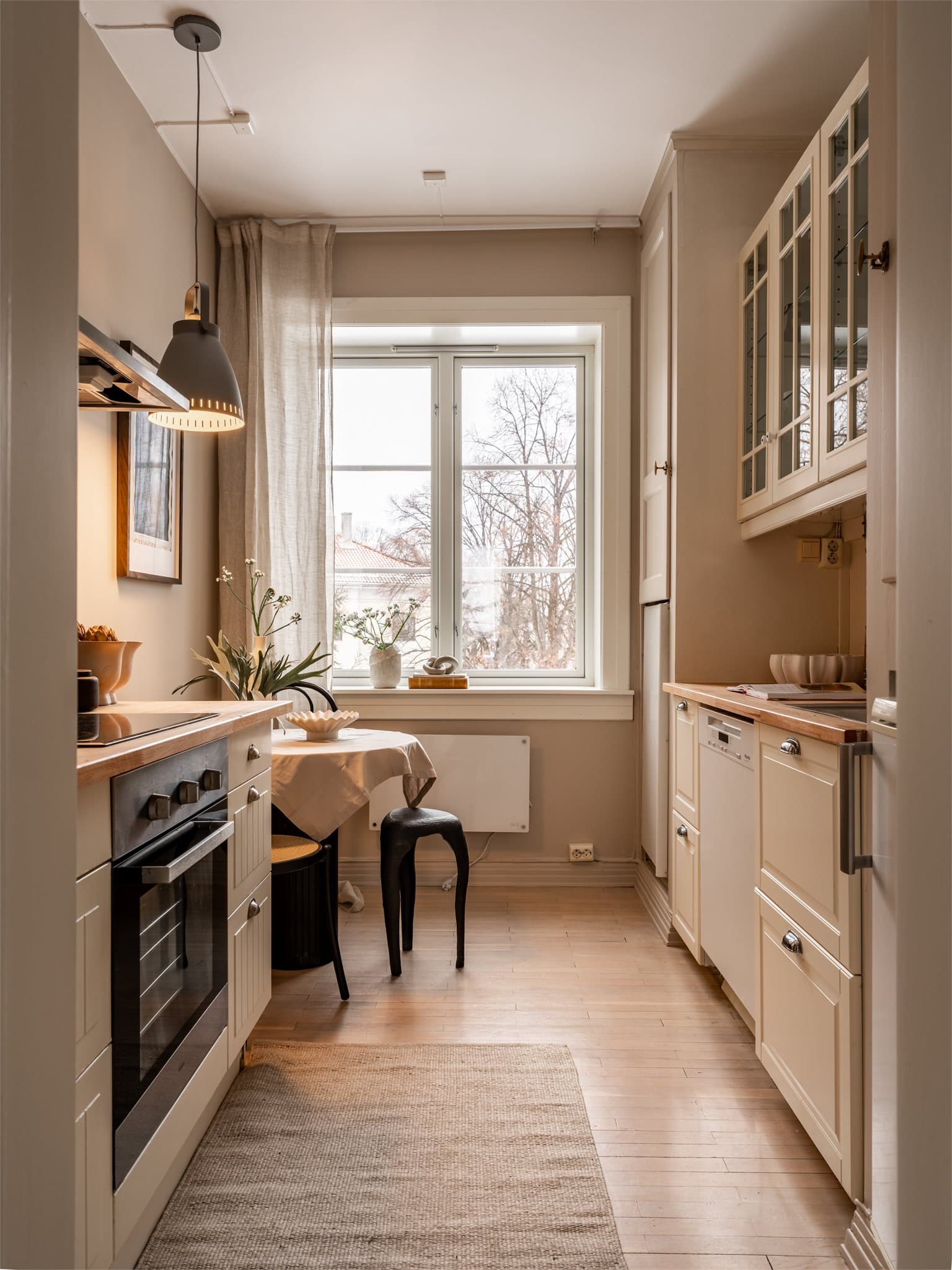 Kjøkkenet er praktisk utformet med god benke- og skapplass på begge sider.