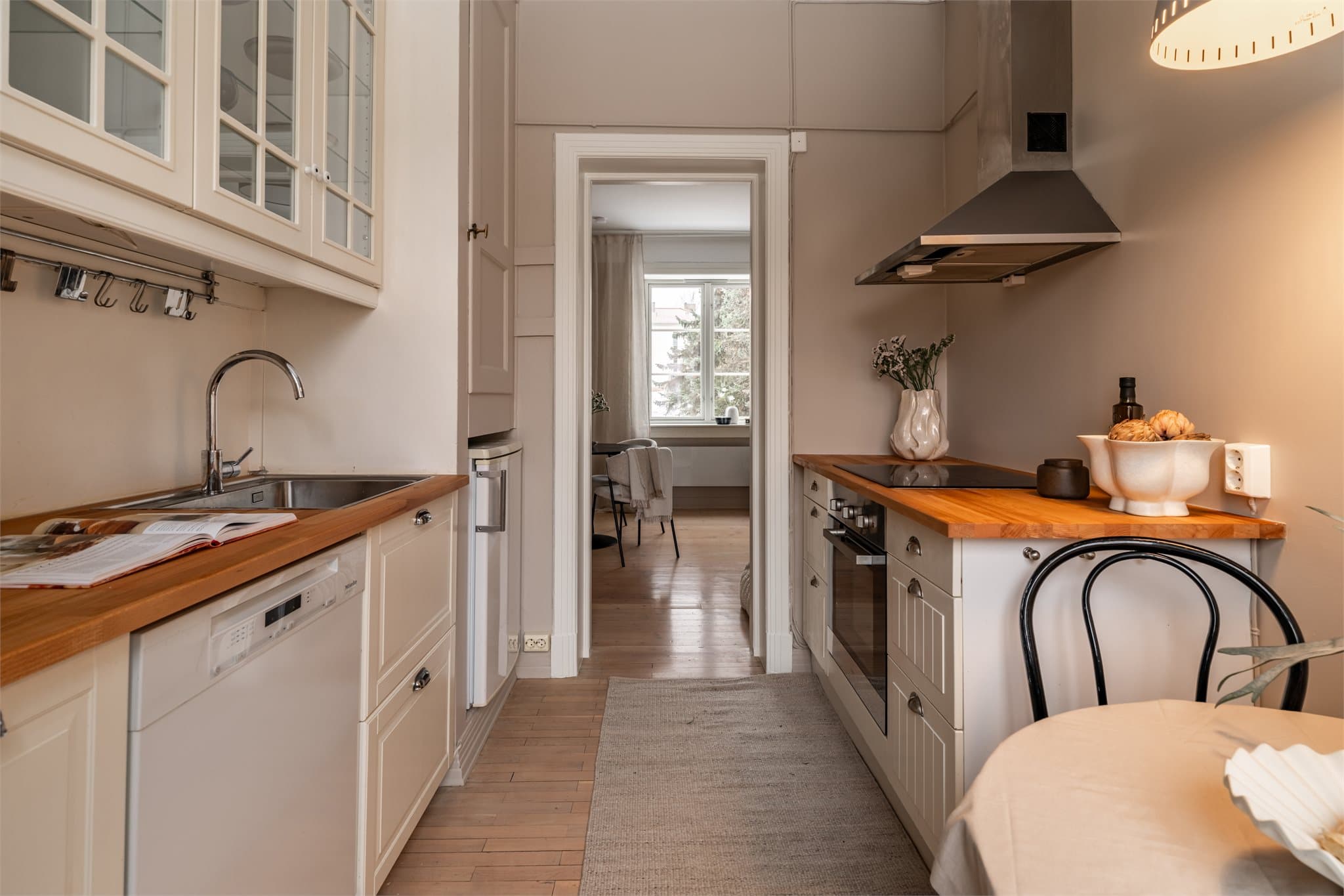 Overskapet tilfører et tidløst, klassisk preg med elegante glassfronter som fremhever servise og detaljer, samtidig som det gir praktisk og god oppbevaringsplass.