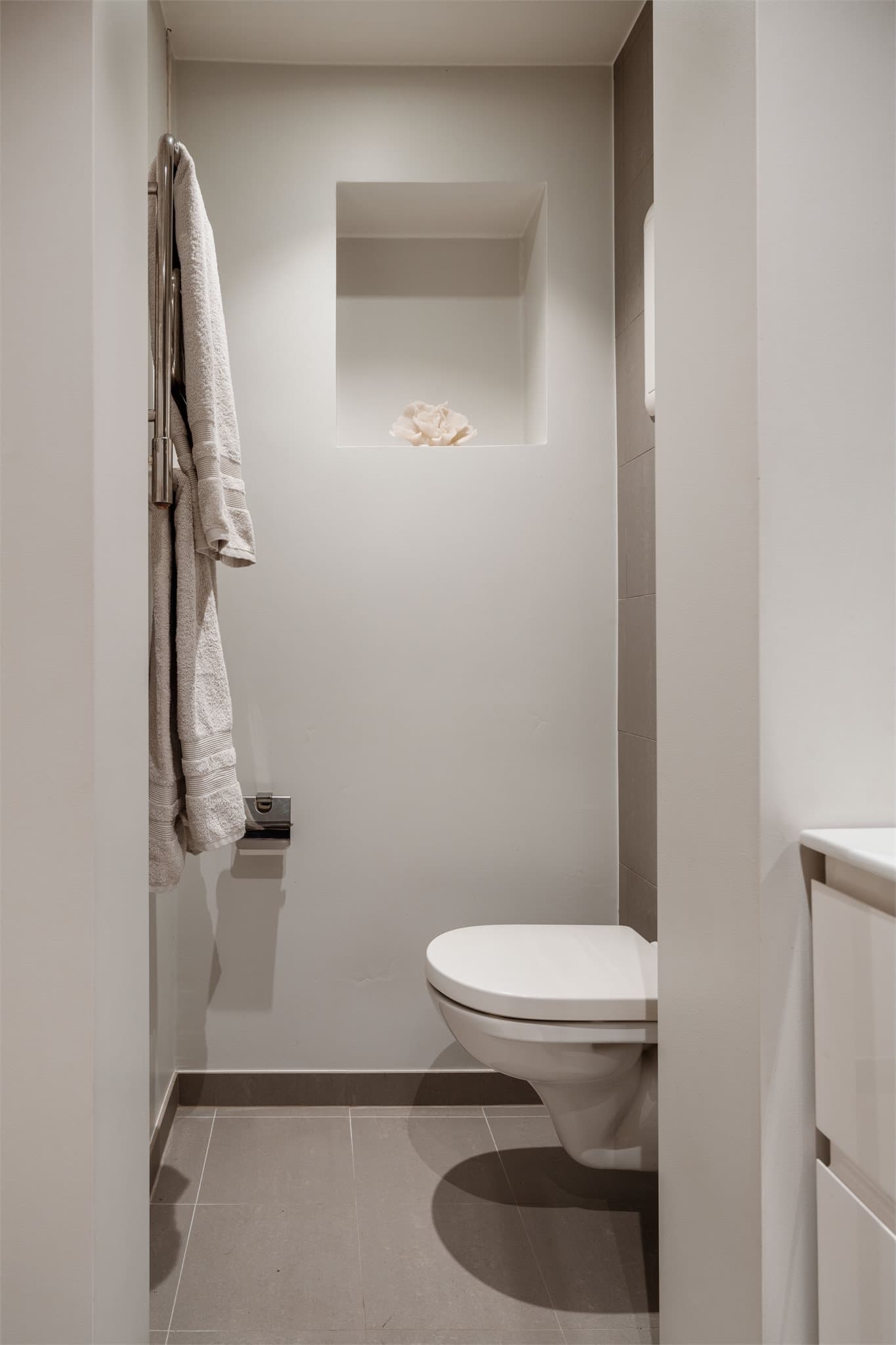 Innredningen er slett med en heldekkende servant og ettgreps blandebatteri. Over vasken er det montert et speil med lys.