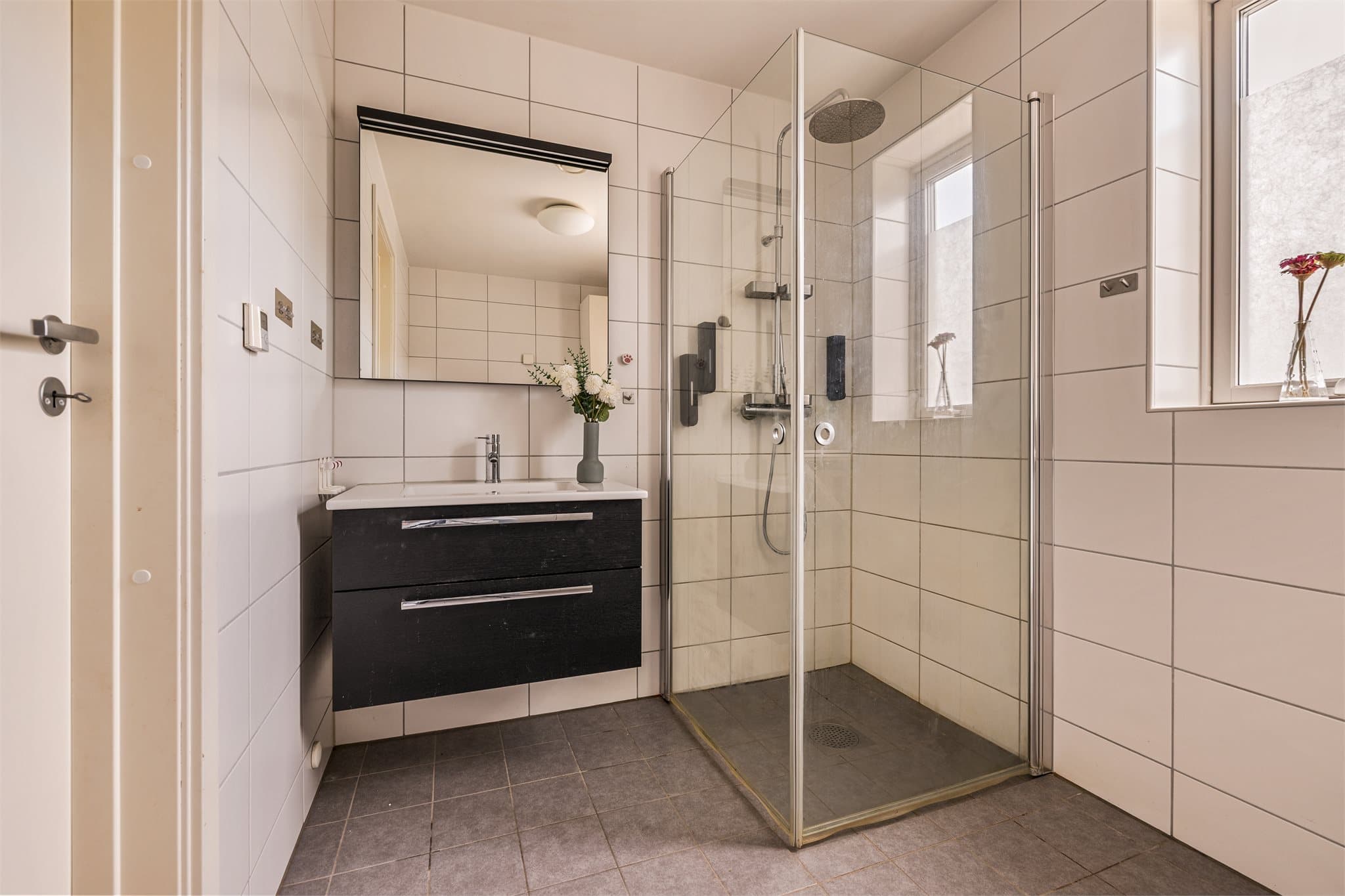 Flislagt bad med dusjhjørne, moderne innredning og gode lysforhold.