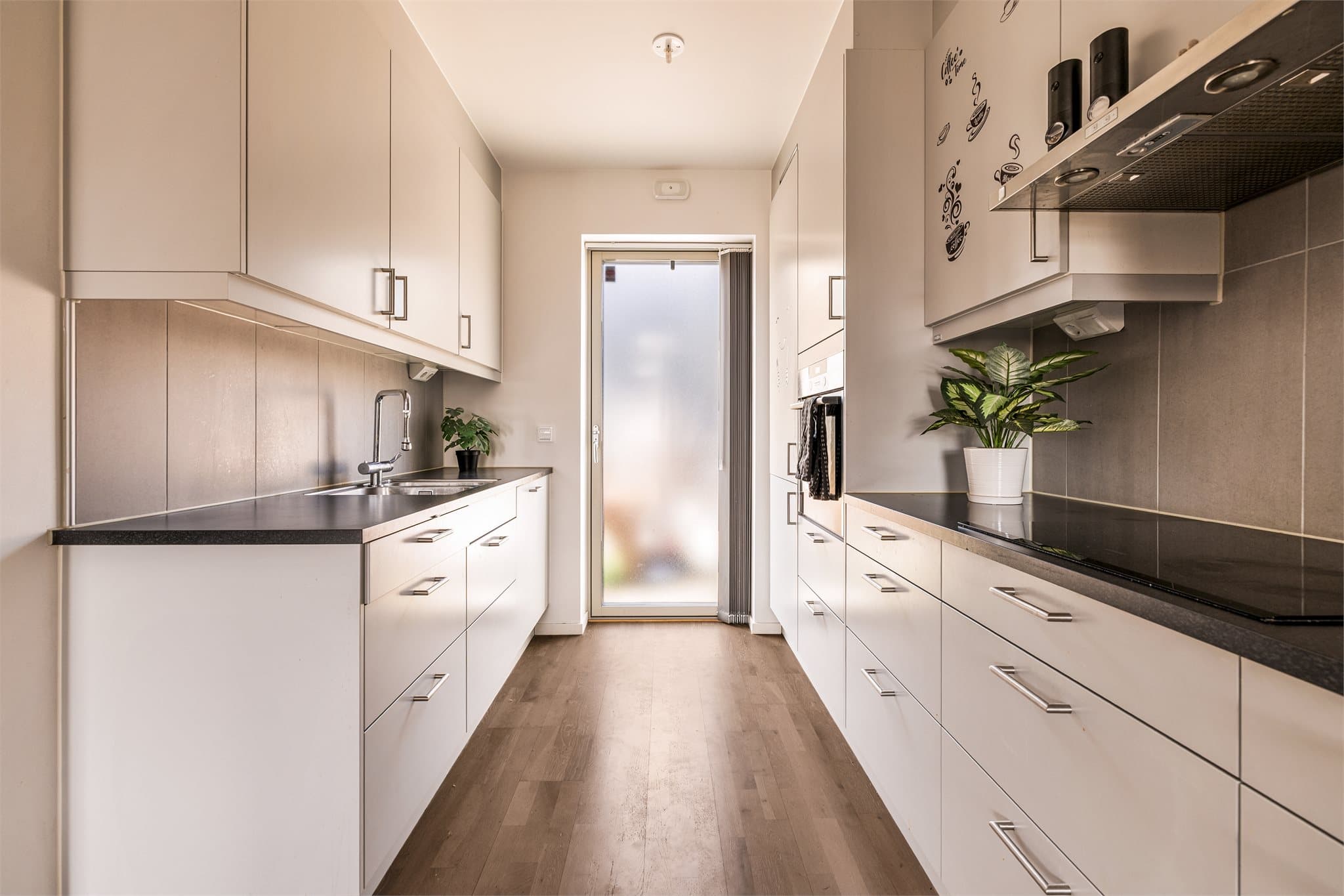 Stilrent kjøkken med integrerte hvitevarer og gode arbeidsflater.