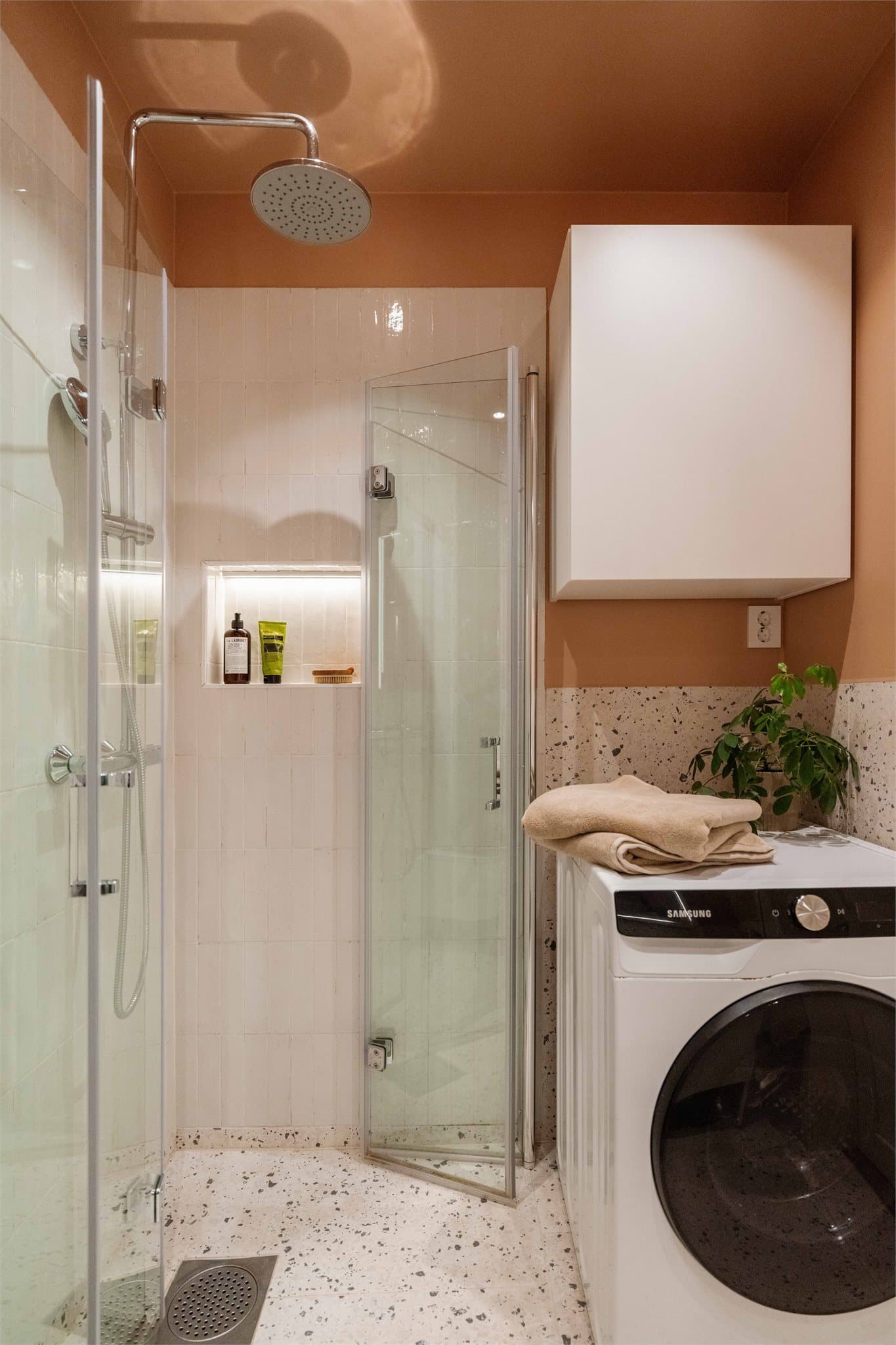 Badet har et moderne og funksjonelt uttrykk med flislagte vegger og malte flater over.