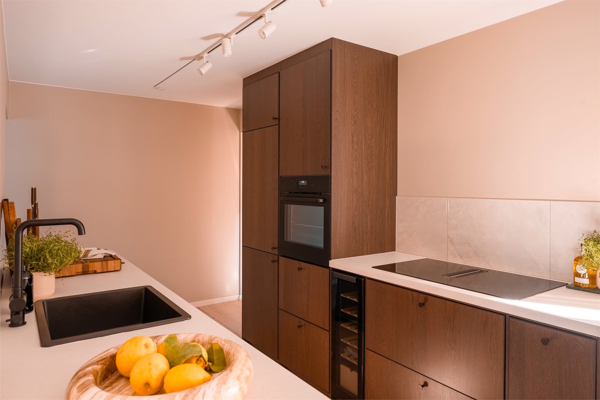 Stilrent kjøkken med integrerte hvitevarer.