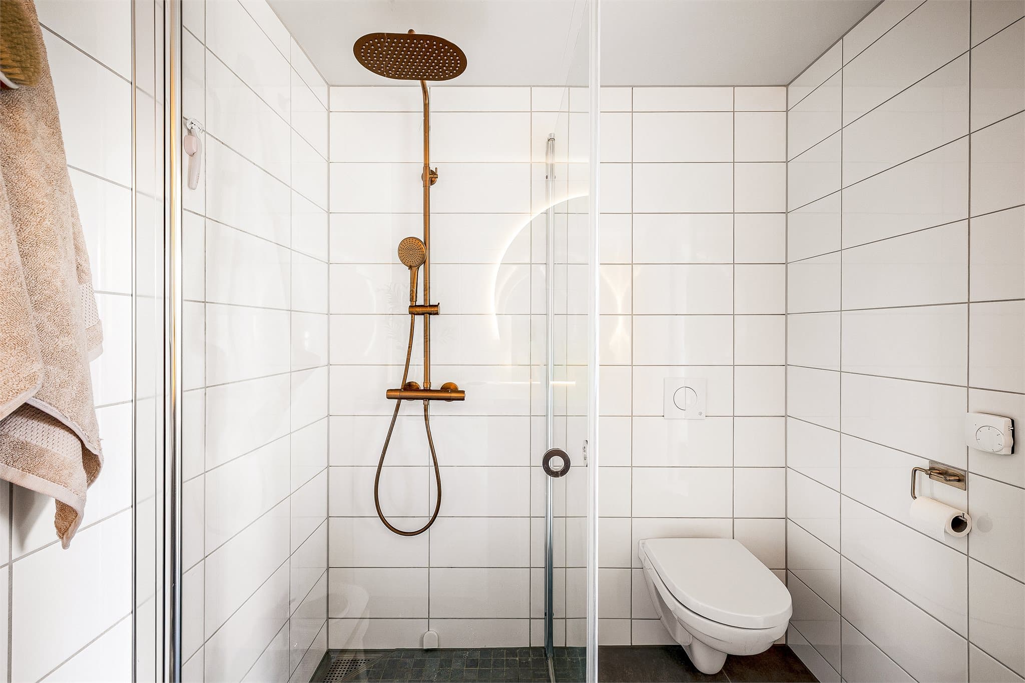 - Badet er innredet med servant med møblement og benkeplate, speil med belysning, høyskap, vegghengt toalett, innfellbart dusjhjørne i glass og opplegg for vaskemaskin -