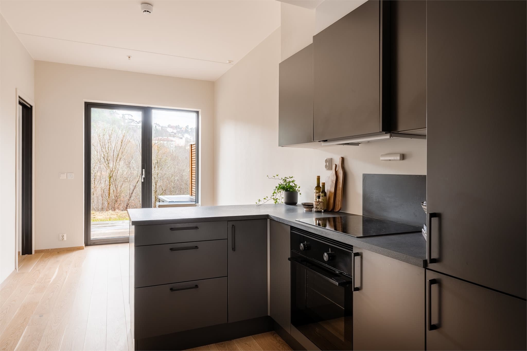 Kjøkkenet er stilrent og funksjonelt, med glatte skapfronter og en laminat benkeplate