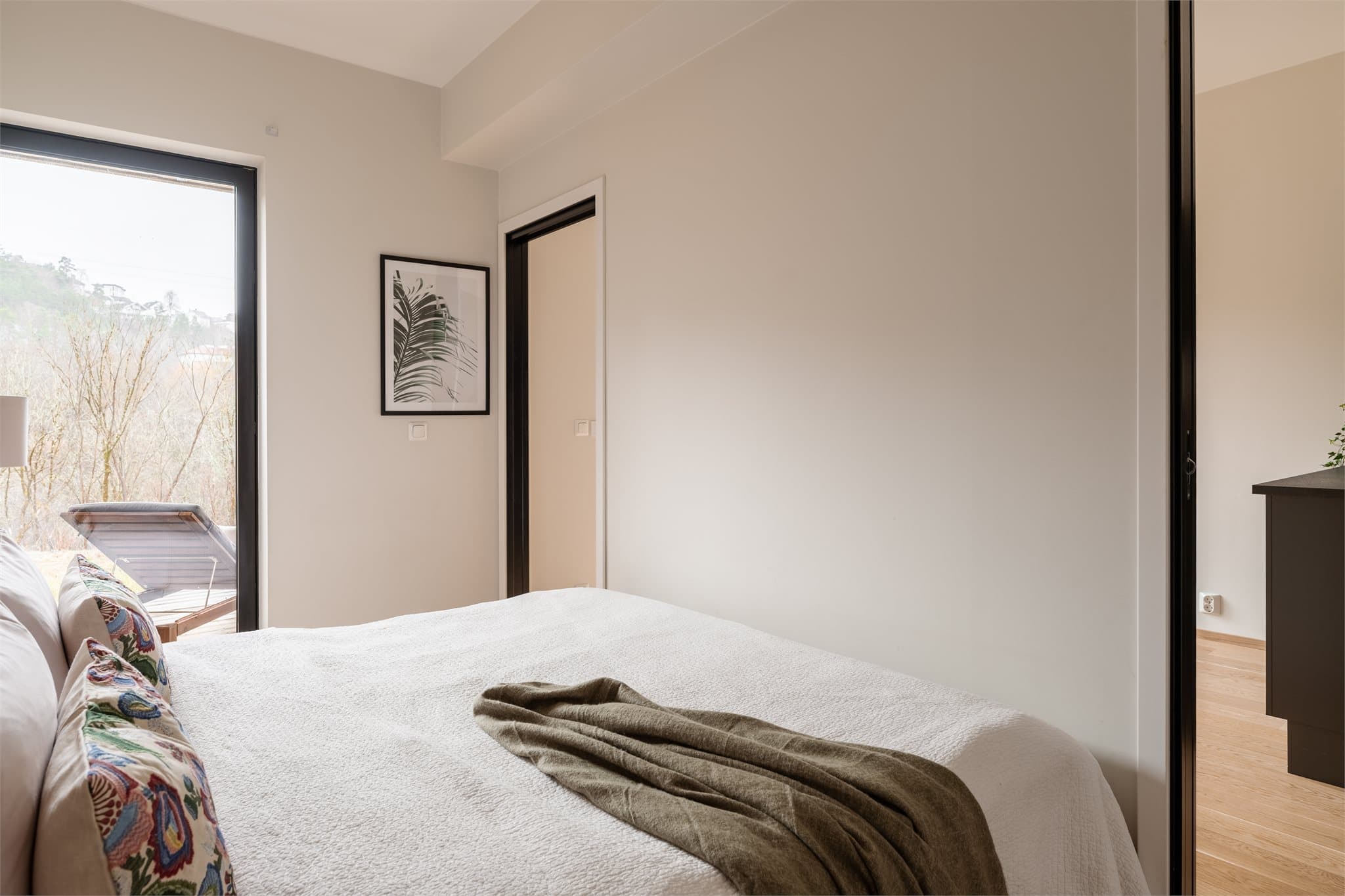 Store vindusflater gir rikelig med naturlig lys og et hyggelig utsyn mot grønne omgivelser