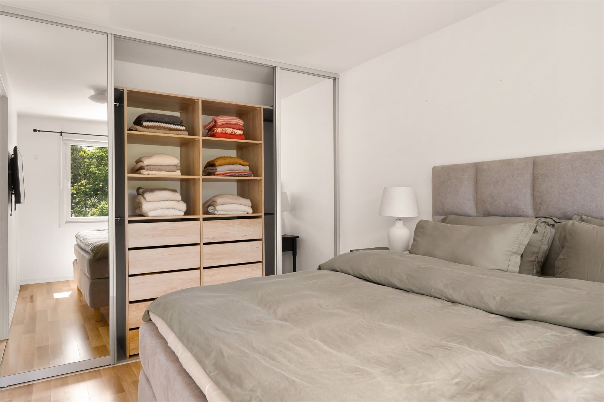 Plassbygd skyvedørsgarderobe med speilfronter gir rikelig oppbevaring.