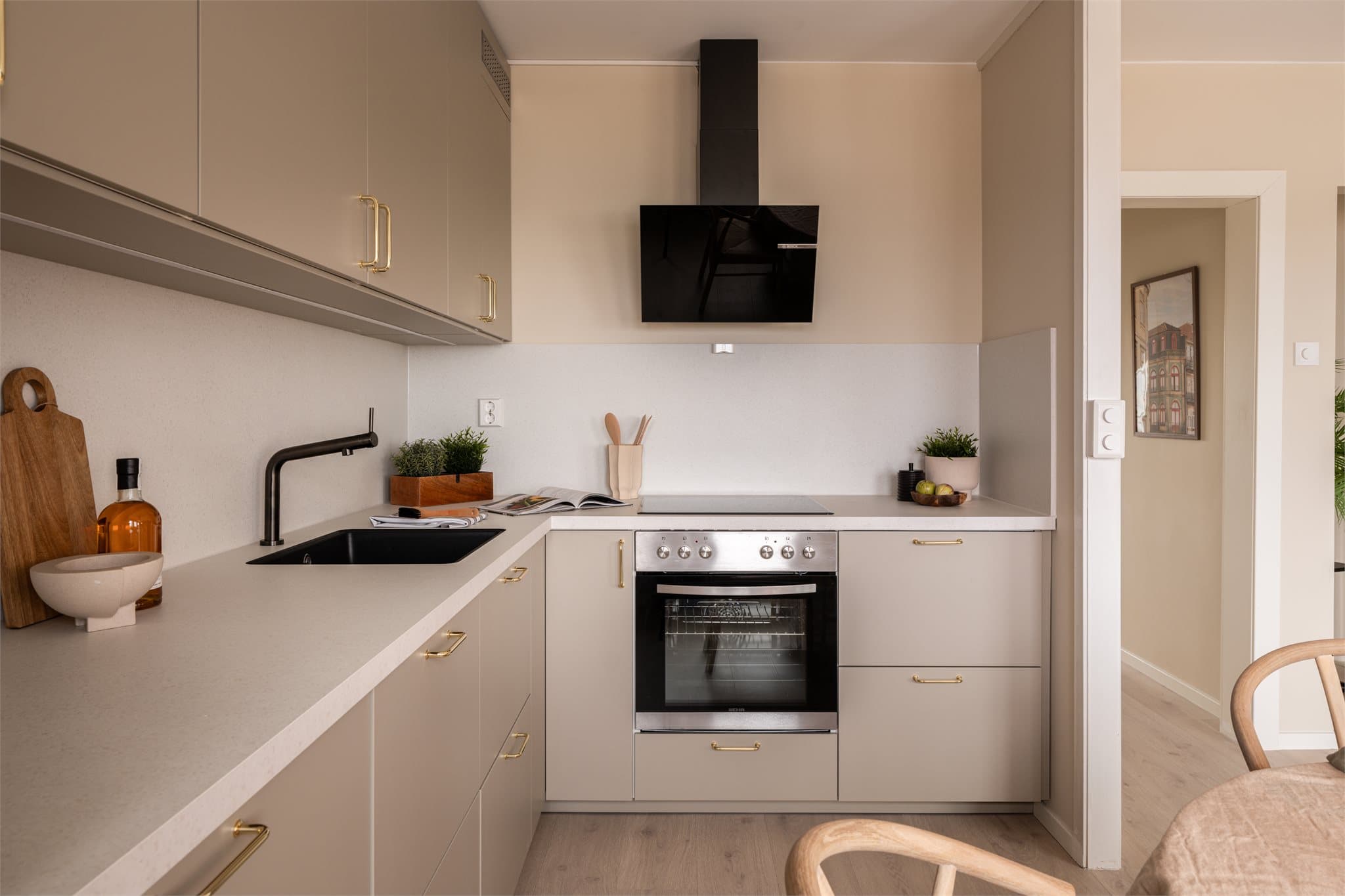 Rålekkert kjøkken i stilren utførelse med glatte fronter, integrerte hvitevarer og gode arbeidsflater.