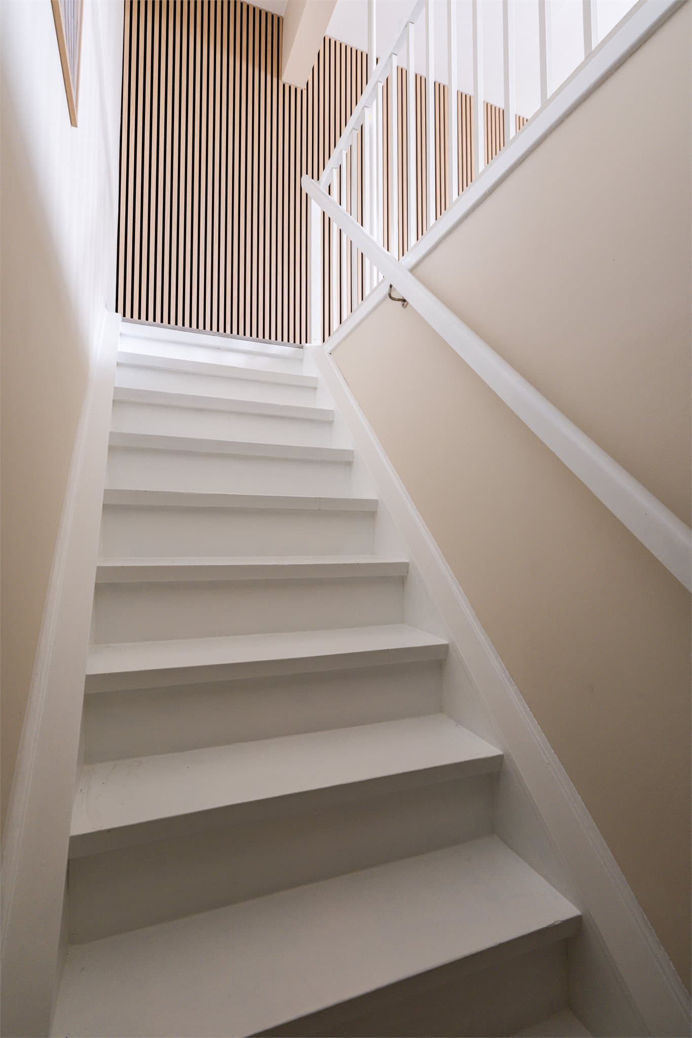 Den hvitmalte trappen binder de to etasjene elegant sammen.