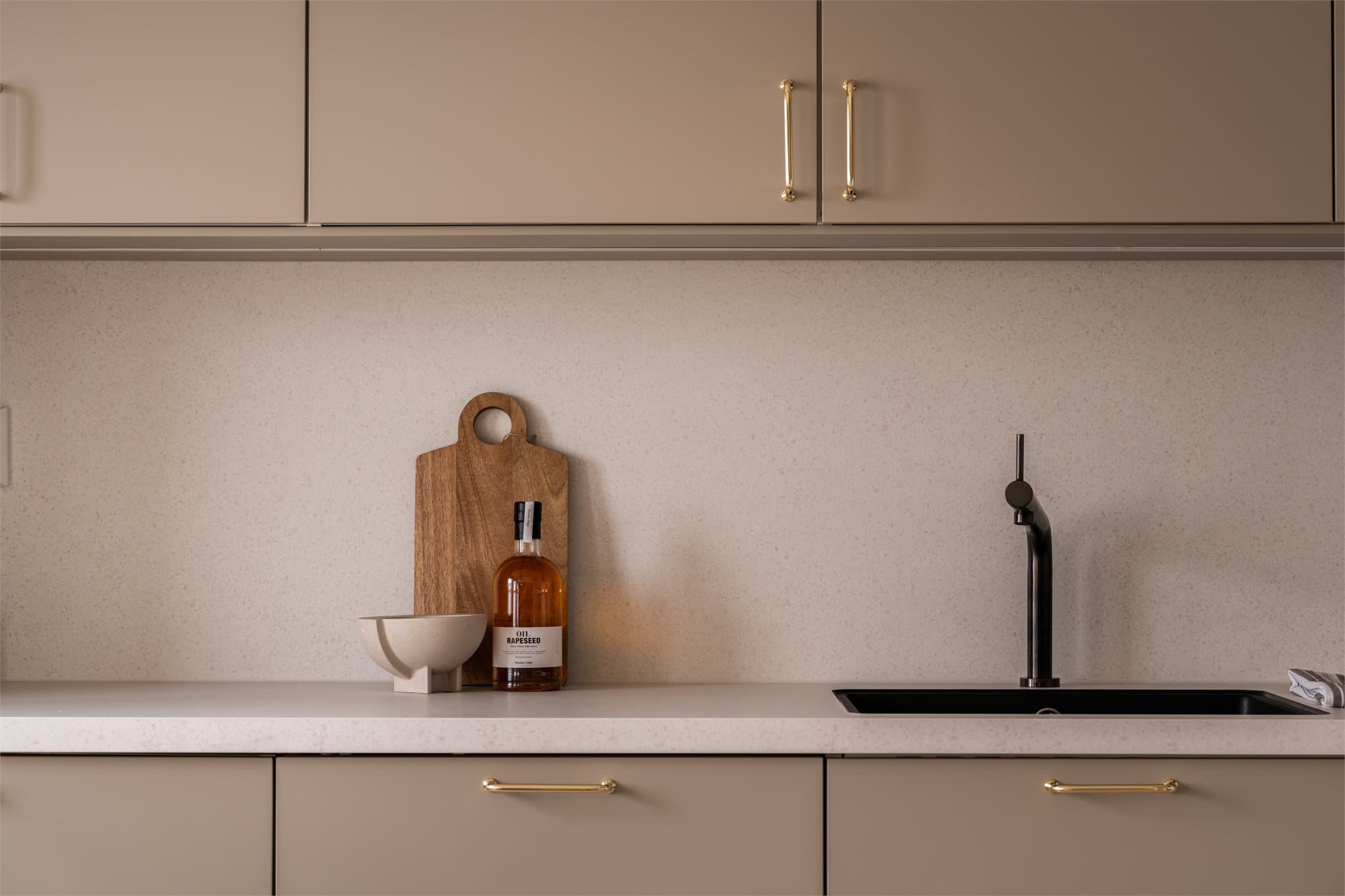 Detaljer som sort blandebatteri og underlimt vask understreker den gjennomførte stilen.